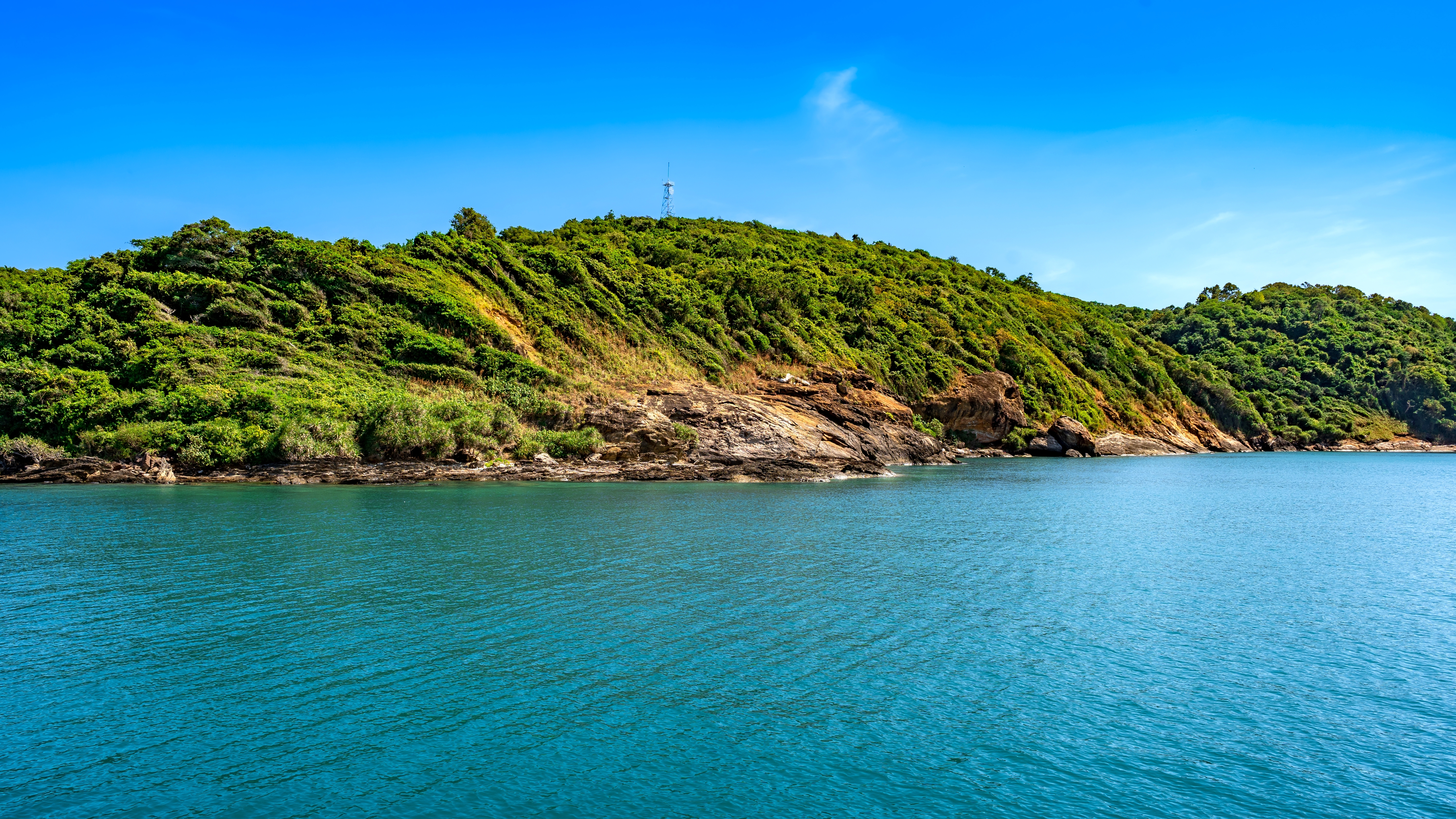 Panoramaudsigt over Koh Sameds frodige tropiske kyst med turkisblåt hav og klar blå himmel i Rayong, Thailand