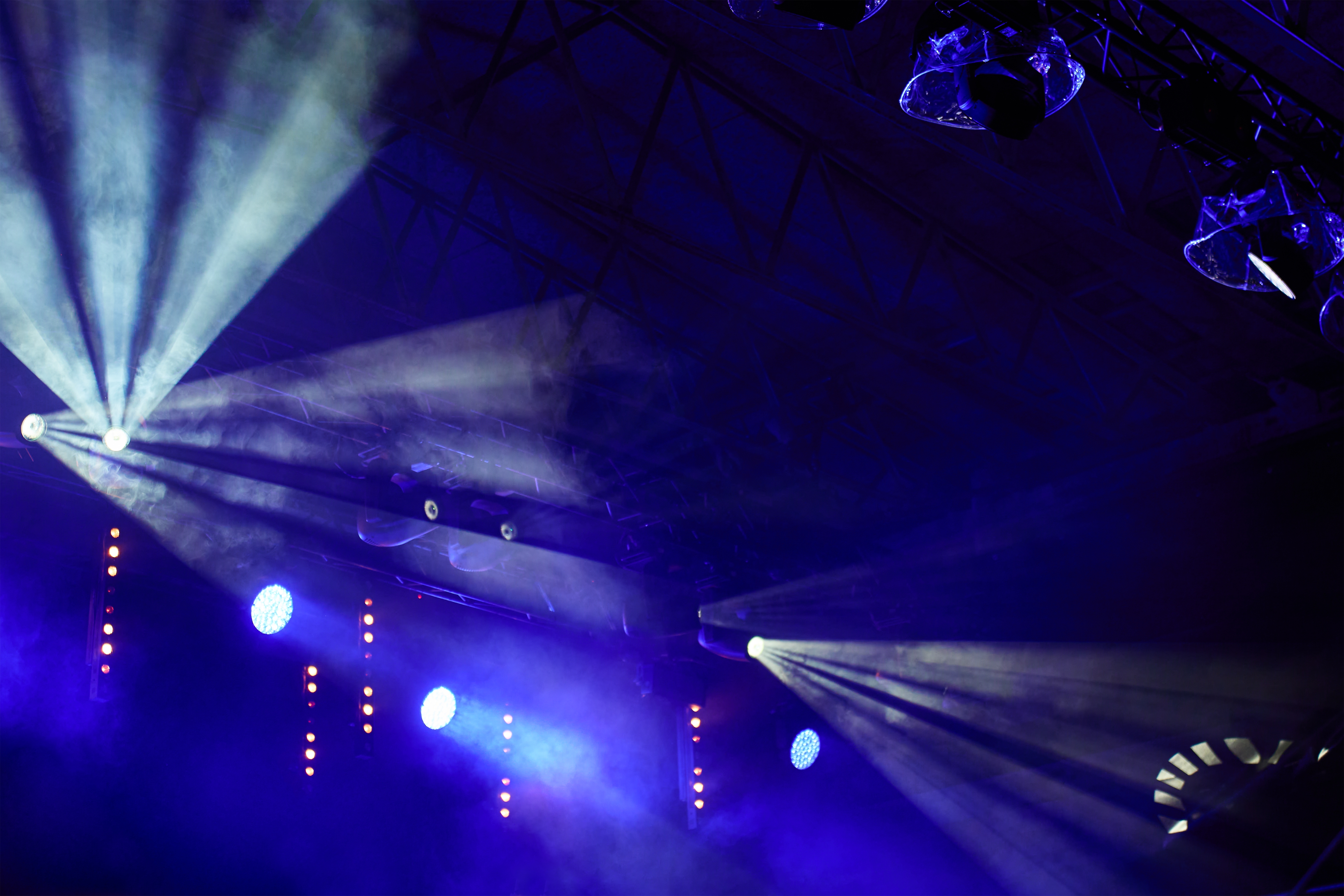 Professionel koncertscene med dynamisk blå belysning og røgeffekter til live musikfestival