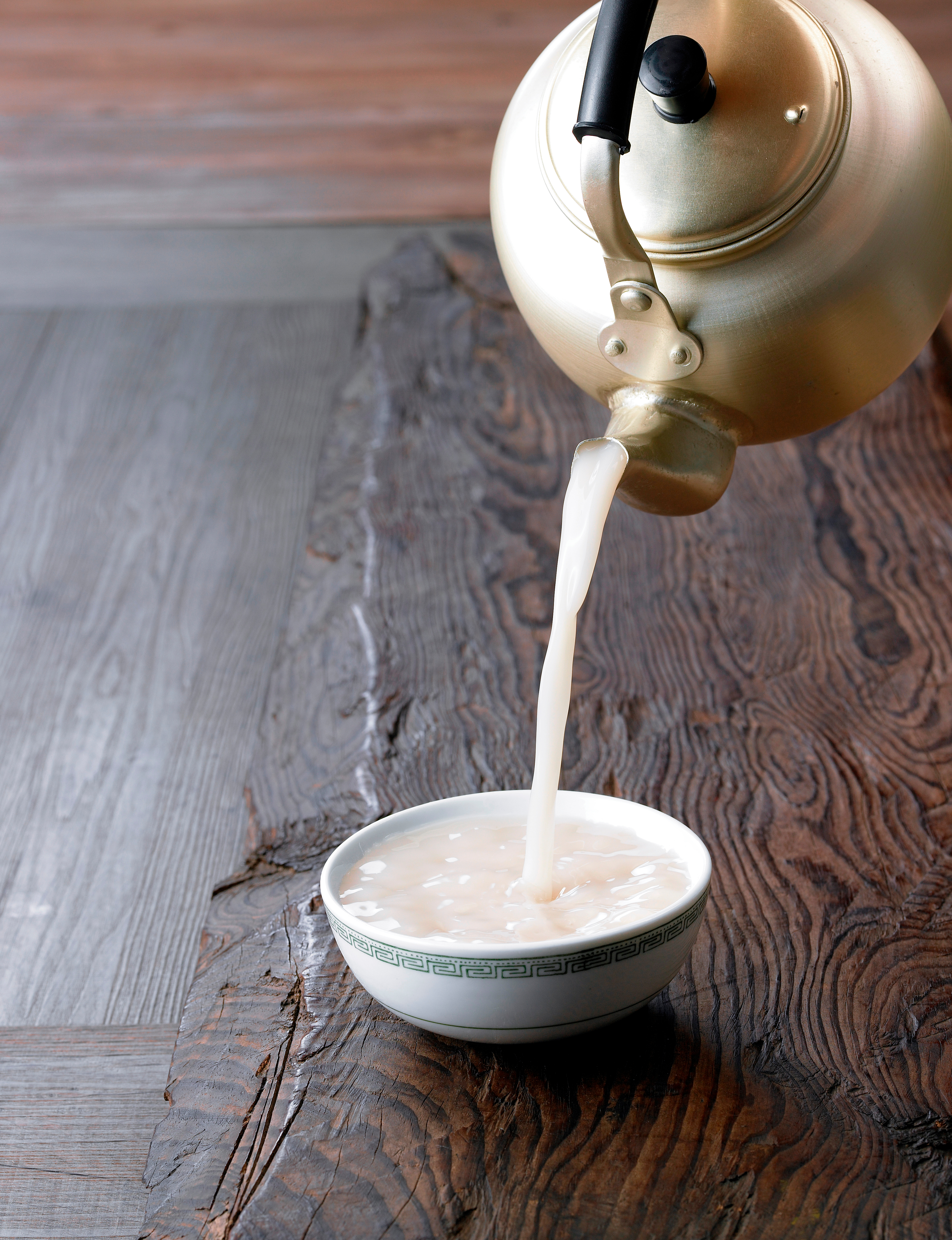 Koreansk Makgeolli, en frisk og sund traditionel risvin med karakteristisk hvid farve serveret i træskål