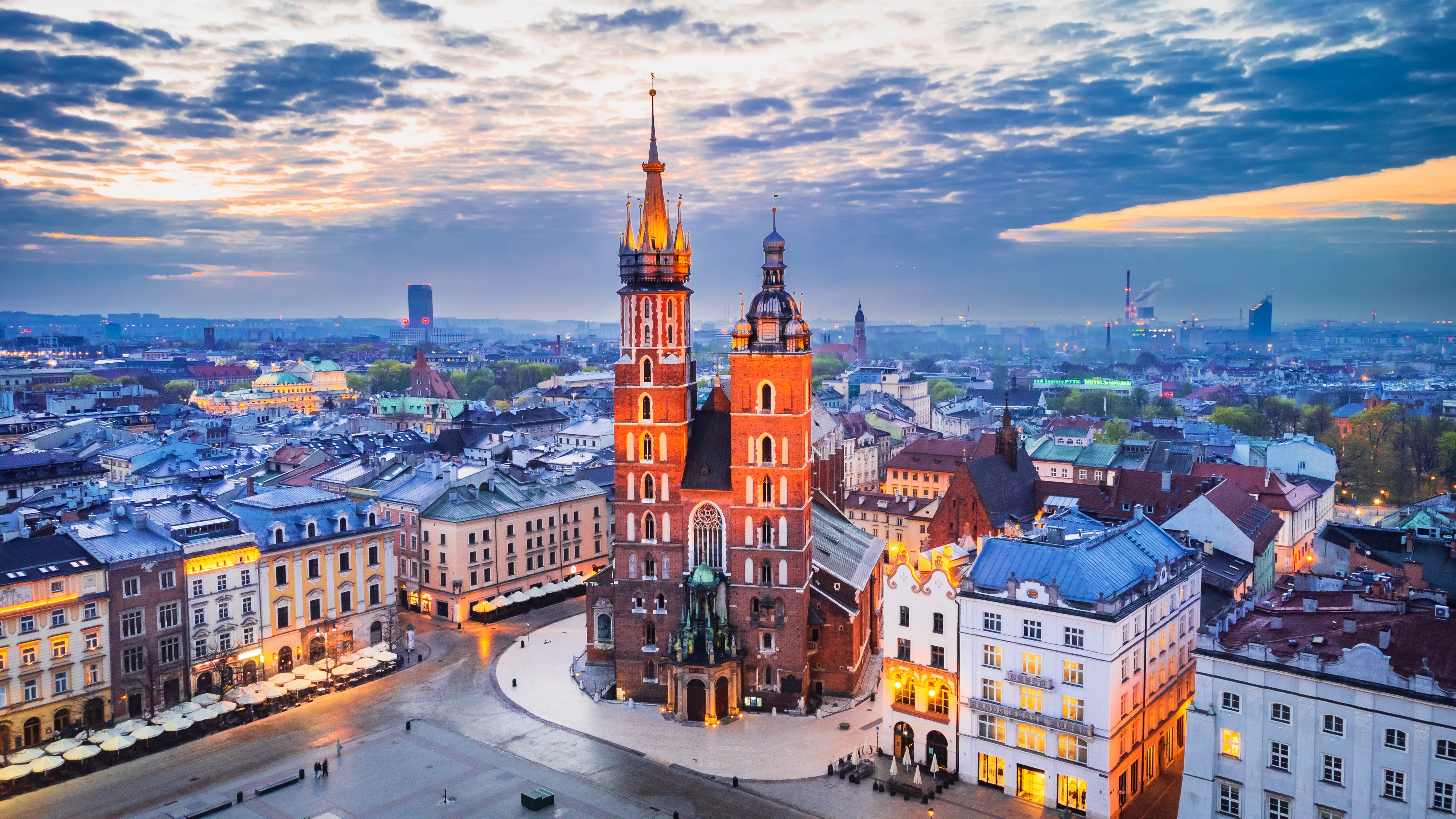Aftenstemning over Krakows hovedtorv med den majestætiske basilika og de oplyste historiske bygninger i Polen