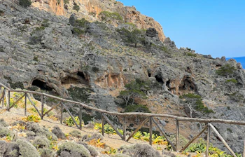 Uberørt natur med markante klippeskrænter og naturlige huler ved Agios Antonios på den vilde sydkyst af Kreta, set fra en vandreesti med trægelænder