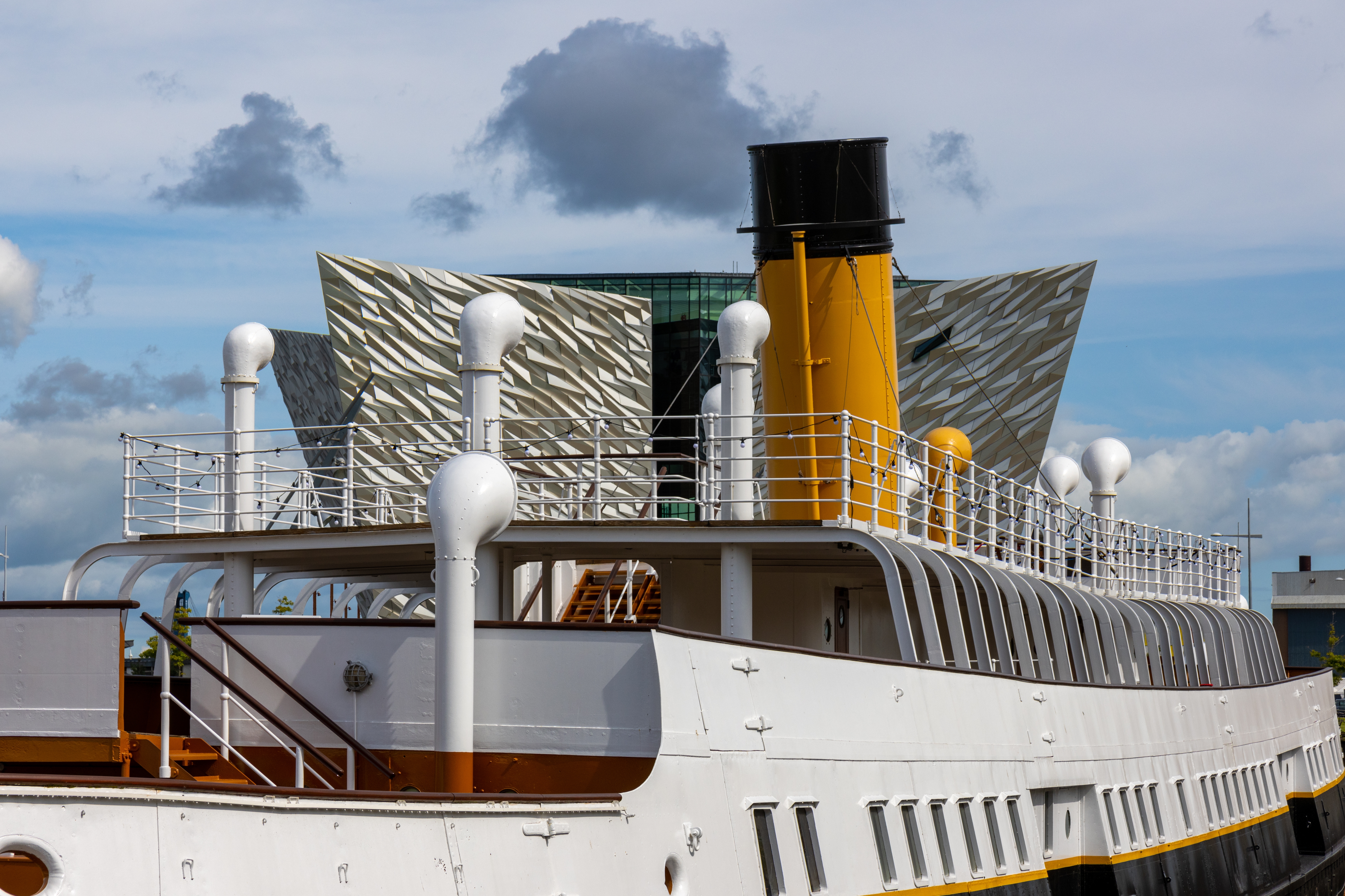 Restaureret krydstogtskib med hvidt skrog ved Titanic Belfast attraktion