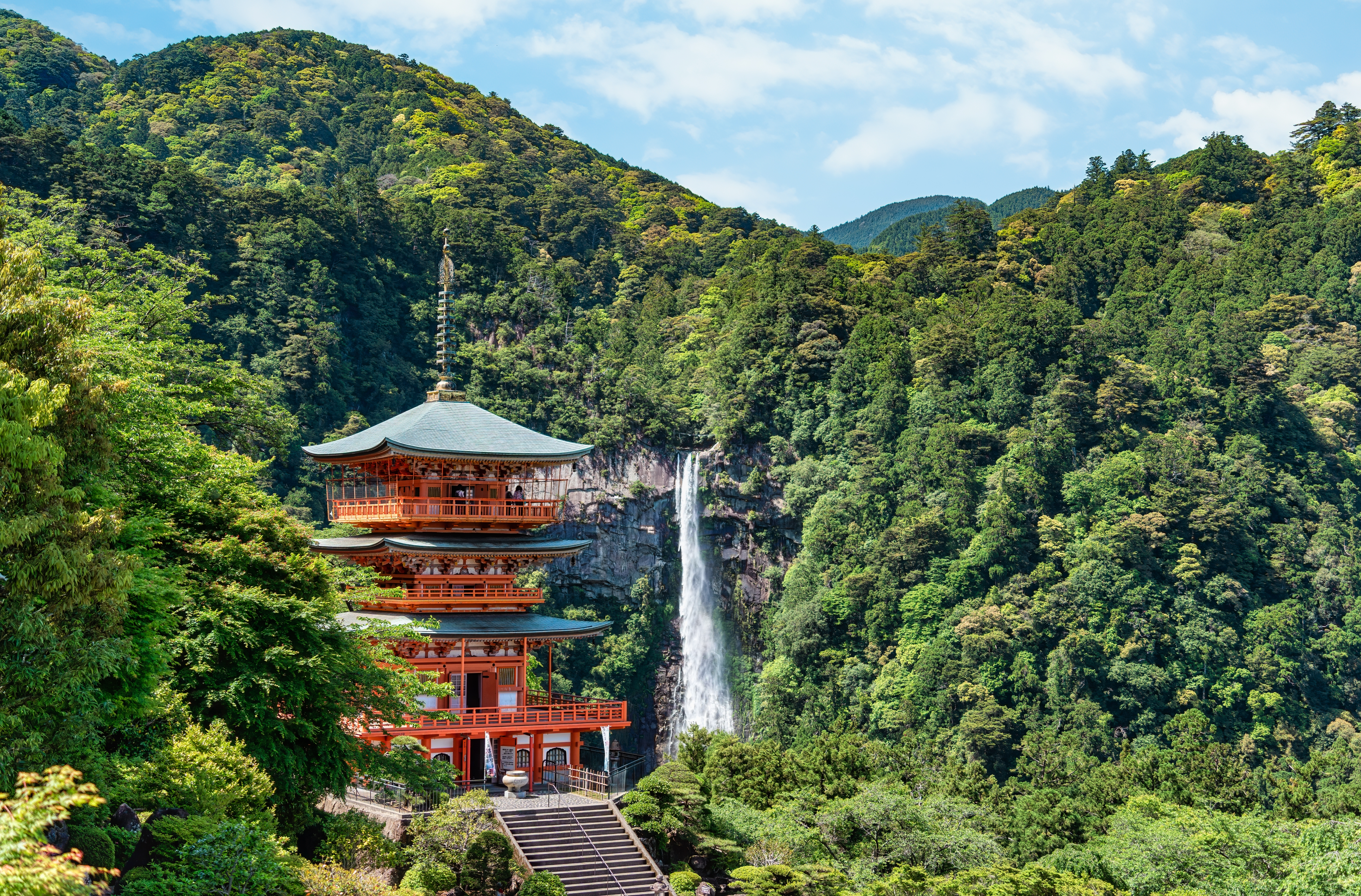 Den rødmalede pagode ved Seiganto-ji tempelet på den hellige Kumano Kodo pilgrimsrute med det storslåede Nachi vandfald i baggrunden, Japan