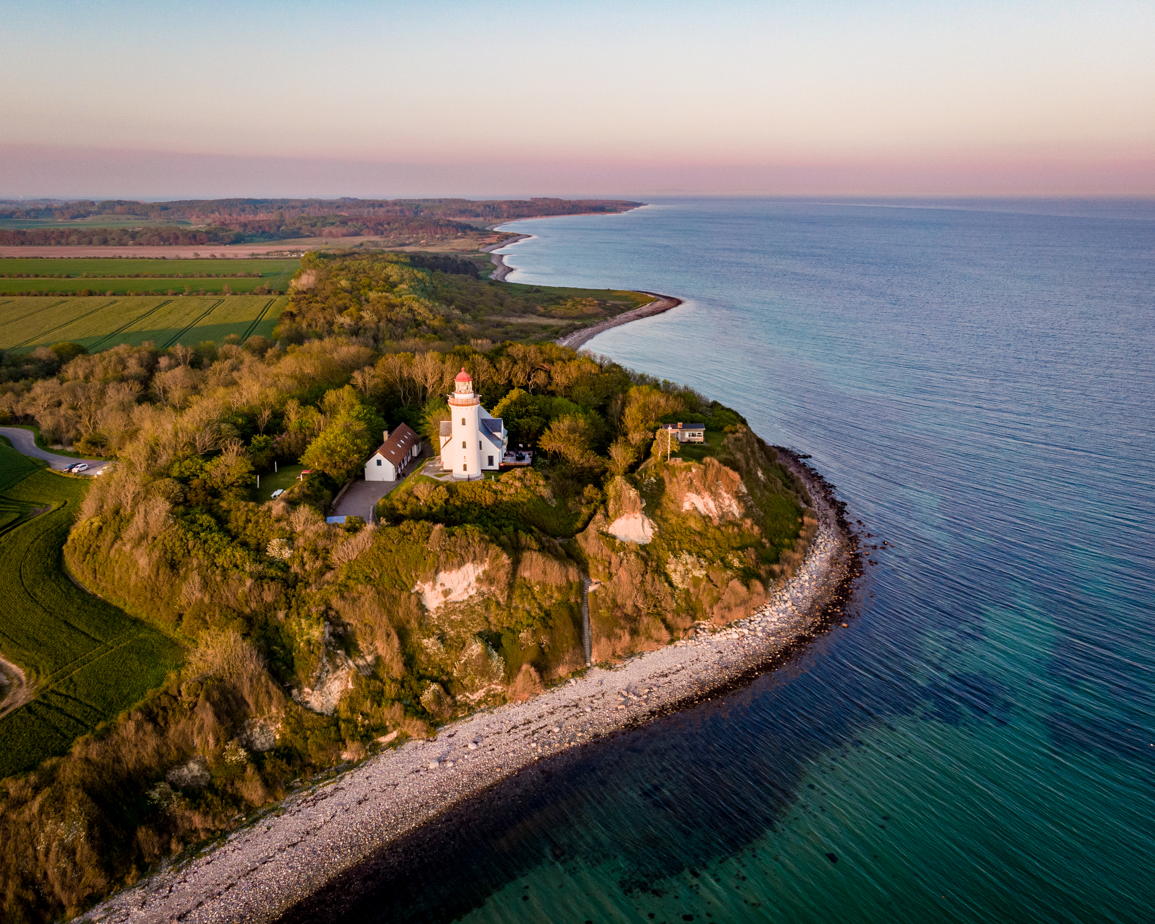 Spektakulært dronefoto af hvidt fyrtårn på klippekyst ved den danske Østersøkyst