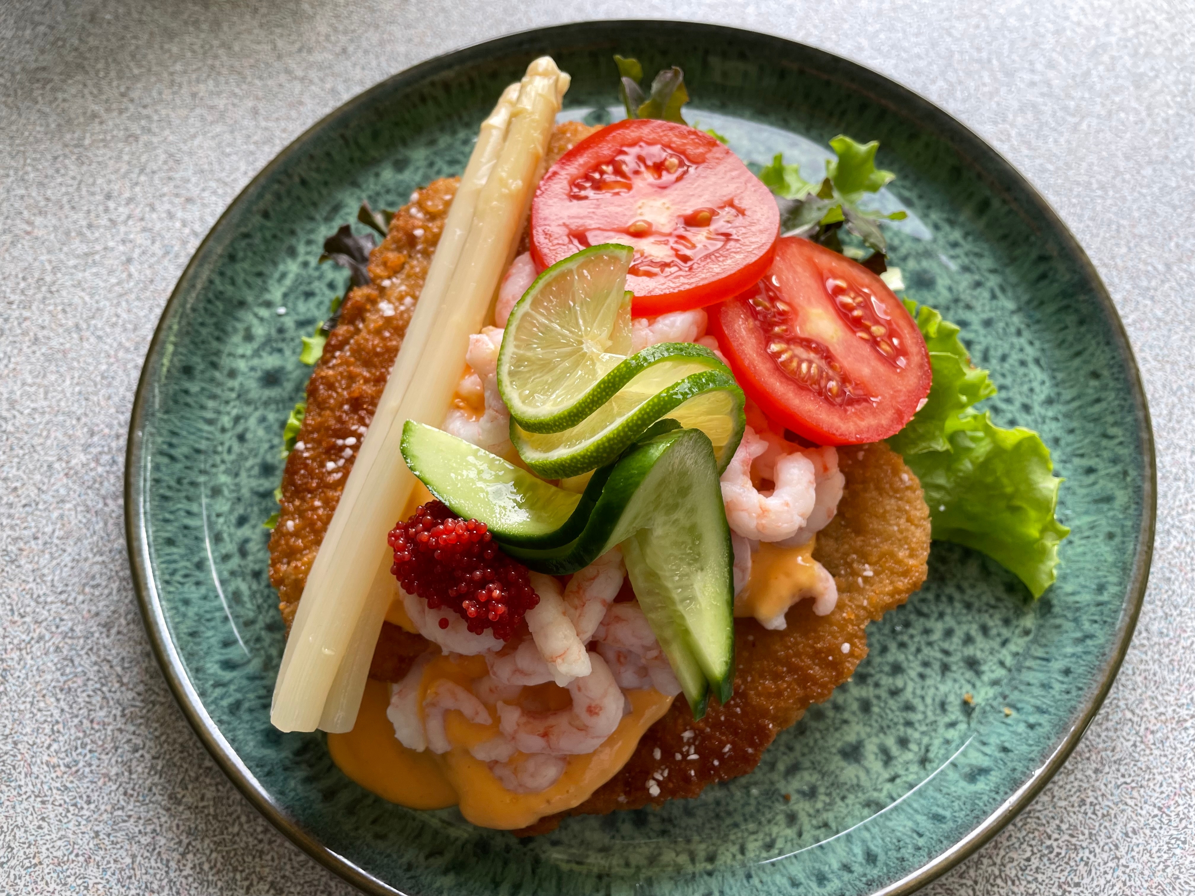 Lækkert fiskemåltid med tomater, agurk og lime på elegant tallerken