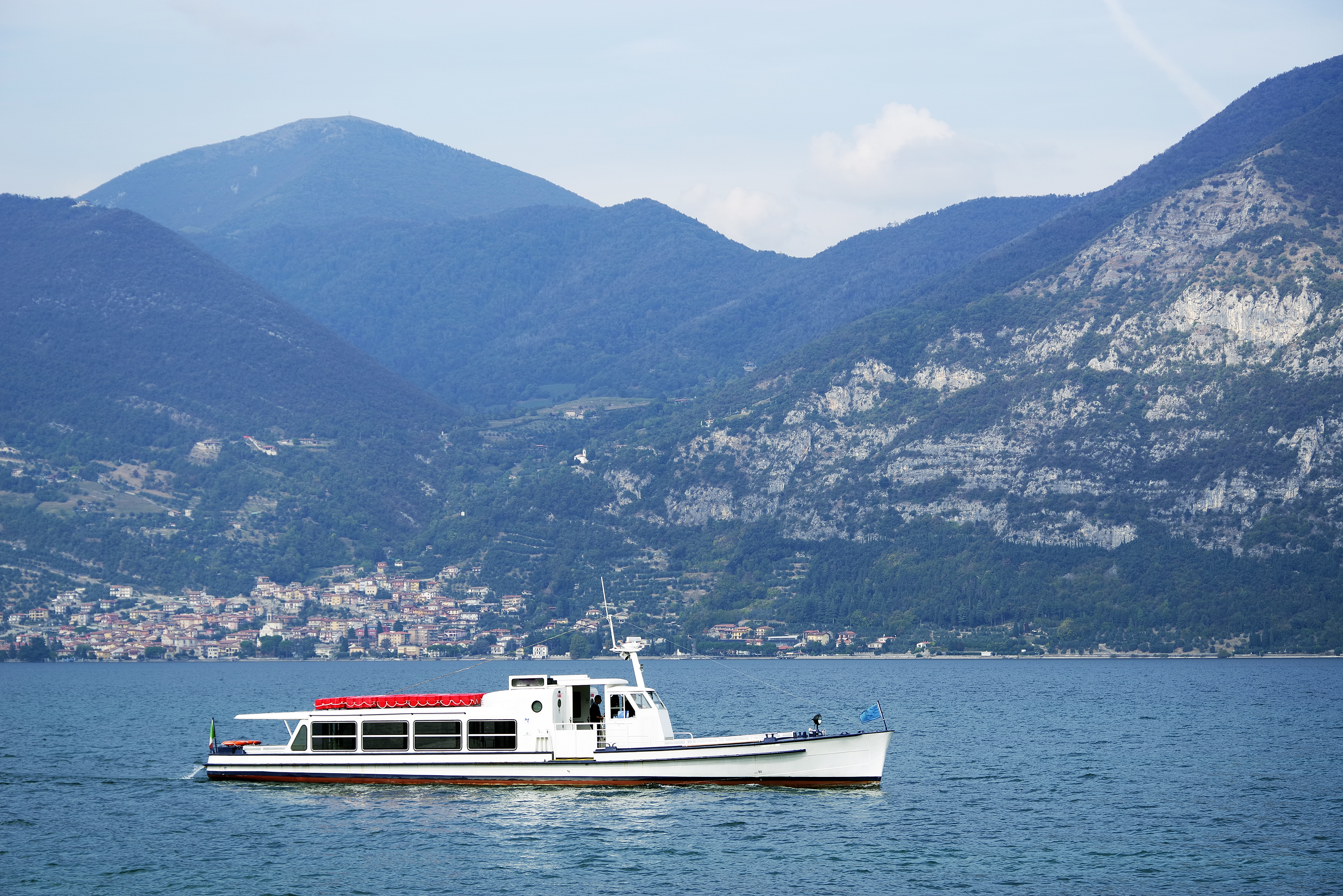 Søfart på Iseo-søen med alperne og charmerende italiensk by ved bredden