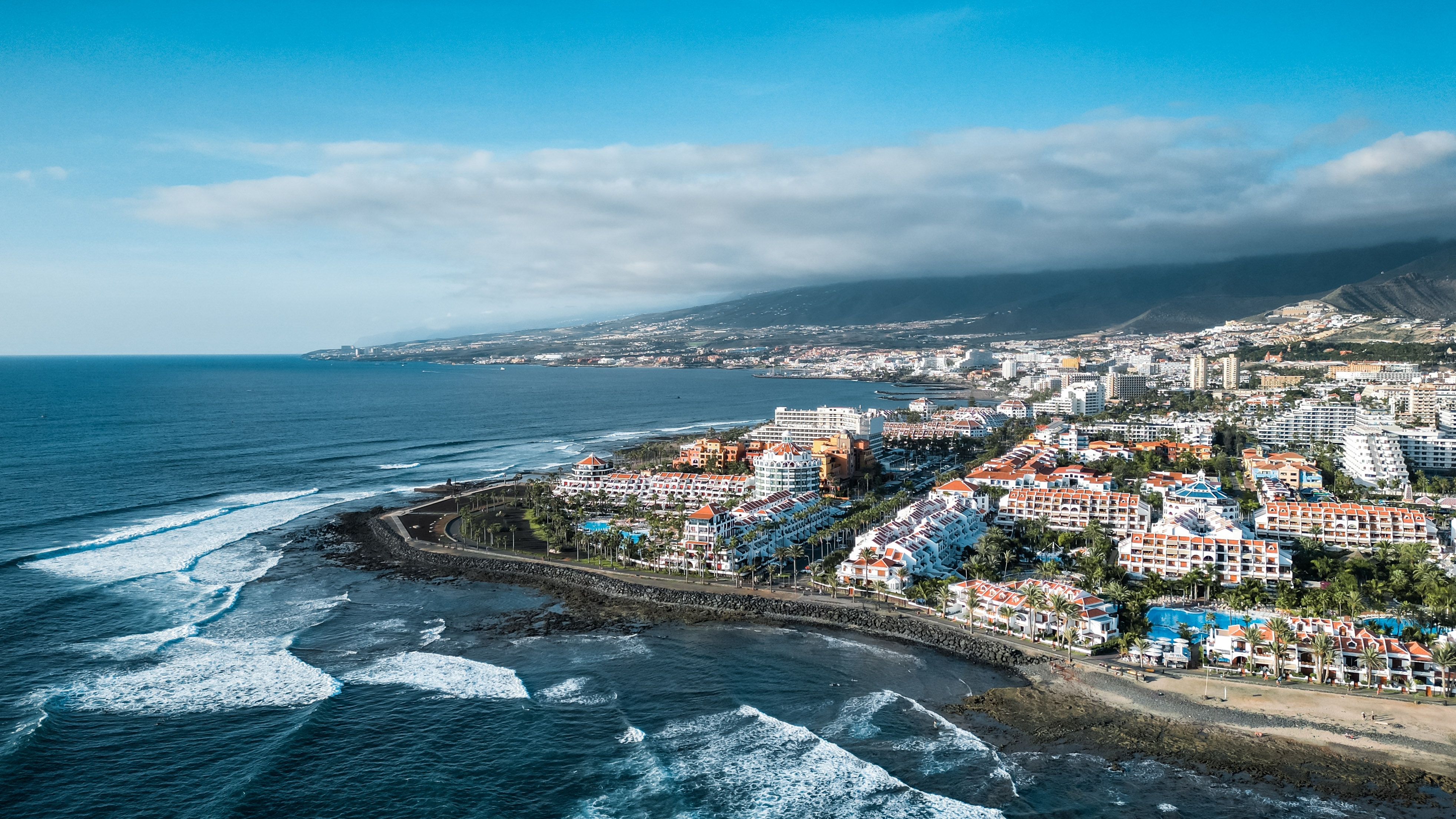 Flot luftfoto over Playa de Las Américas på Tenerife, Kanariske Øer, med turkisblåt hav, strandhoteller og palmer