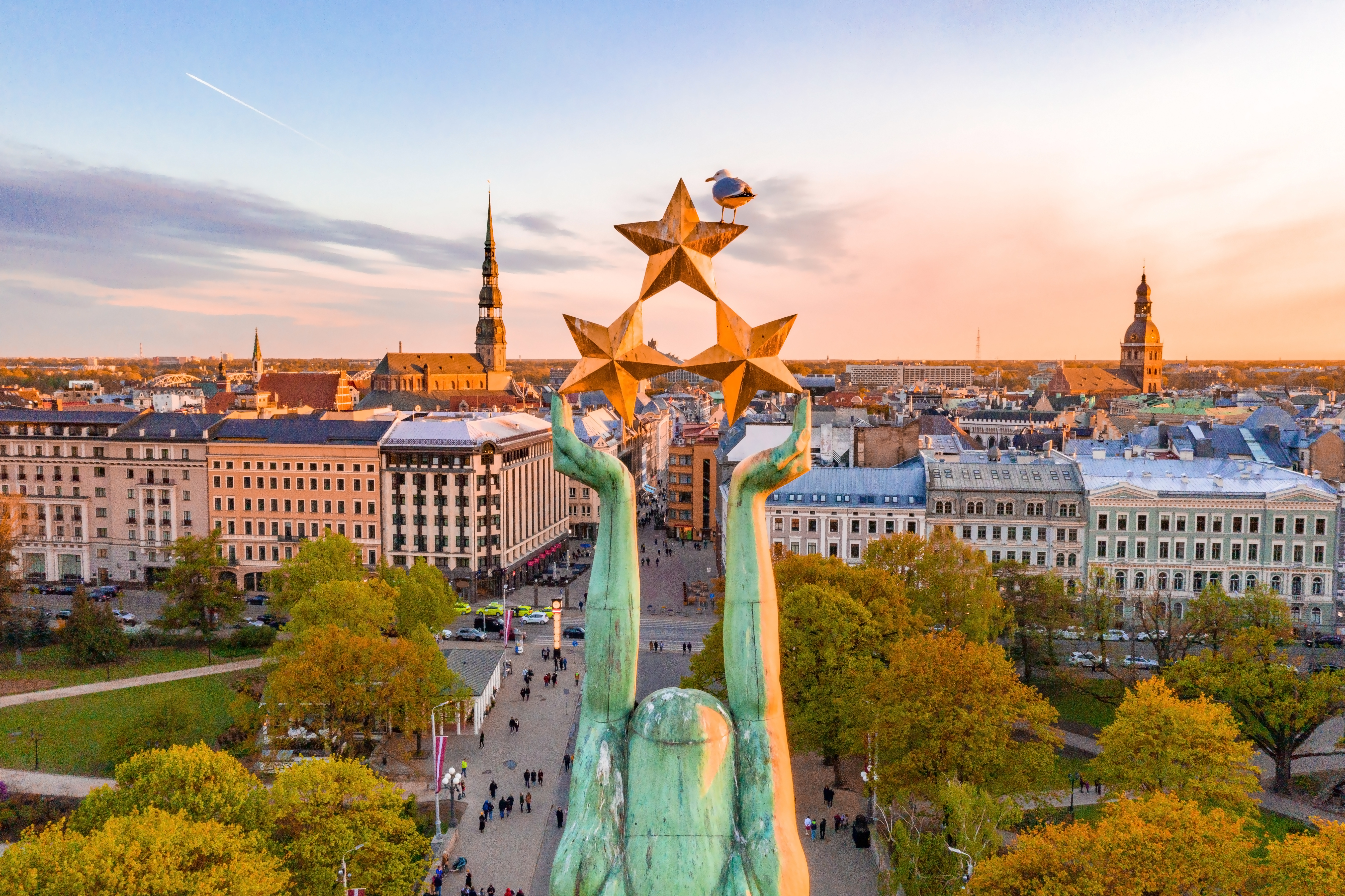 Rigas ikoniske frihedsmonument med gyldne stjerner i solnedgangens lys over den lettiske hovedstad