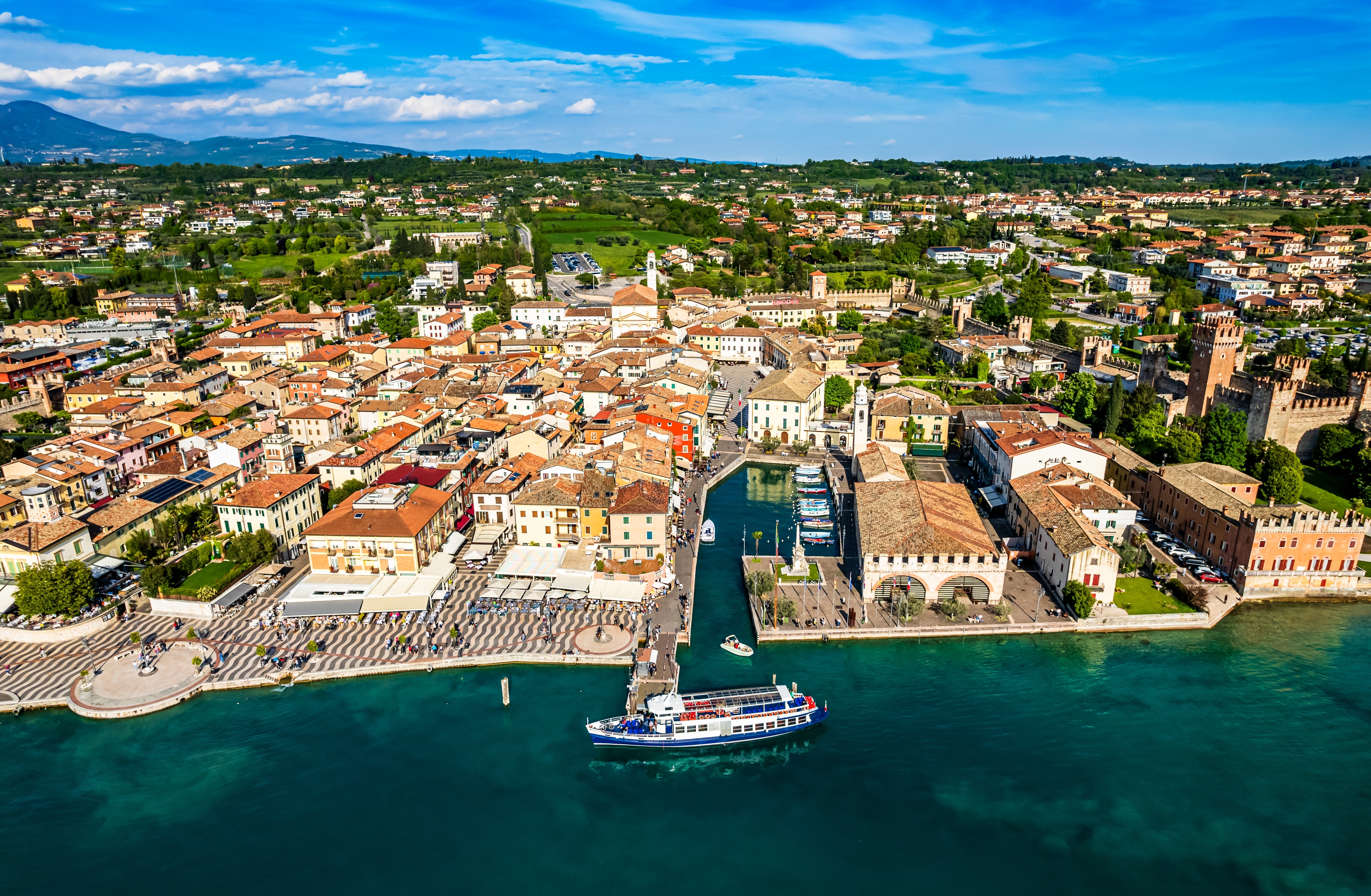 Fascinerende luftudsigt over den charmerende by Lazise med sin hyggelige marina, historiske bygninger og kystpromenade ved det blå Lago di Garda i Italien