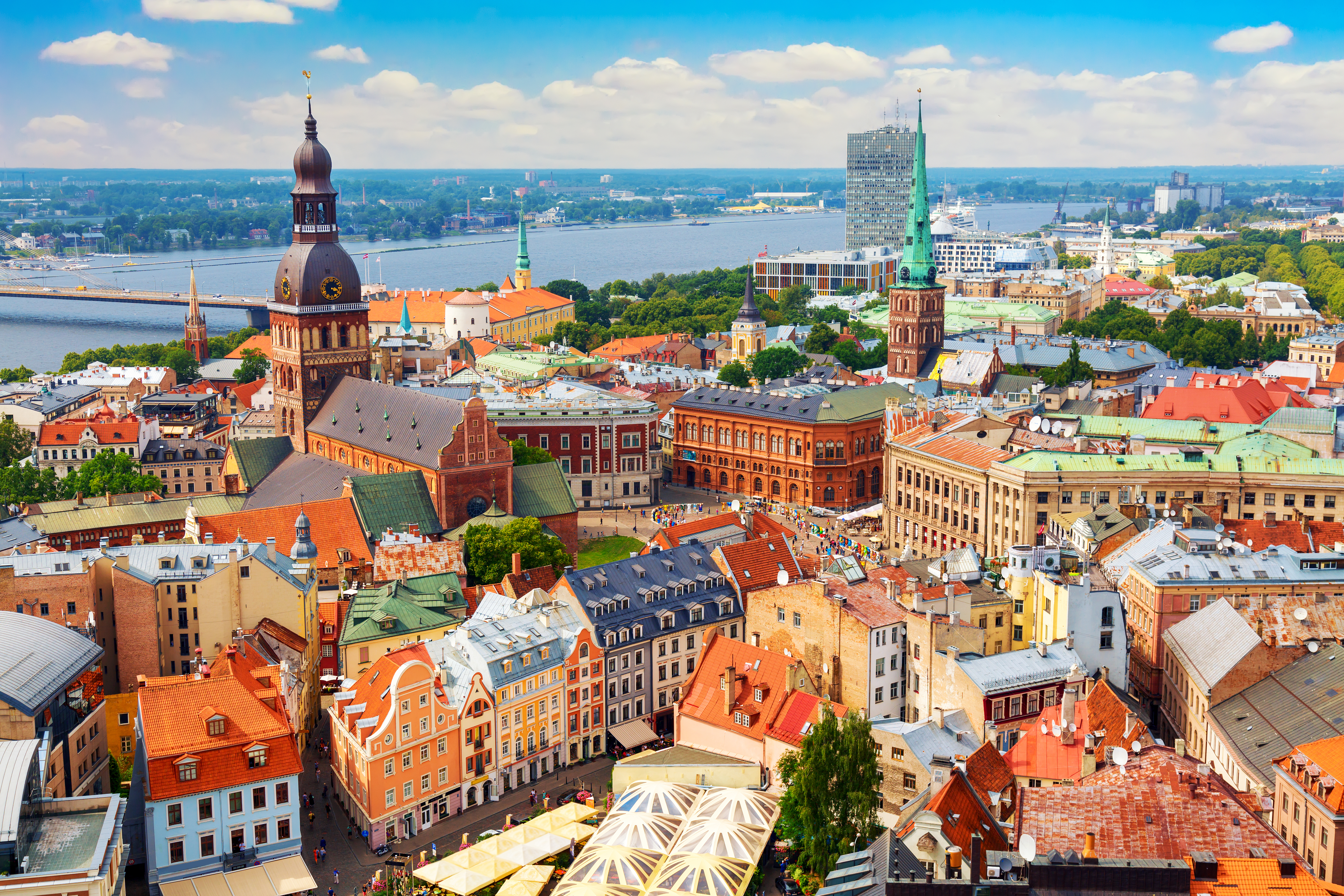 Storslået fugleperspektiv over Rigas historiske centrum med røde tage, kirkespir og middelalderarkitektur, fotograferet fra højden på en klar sommerdag
