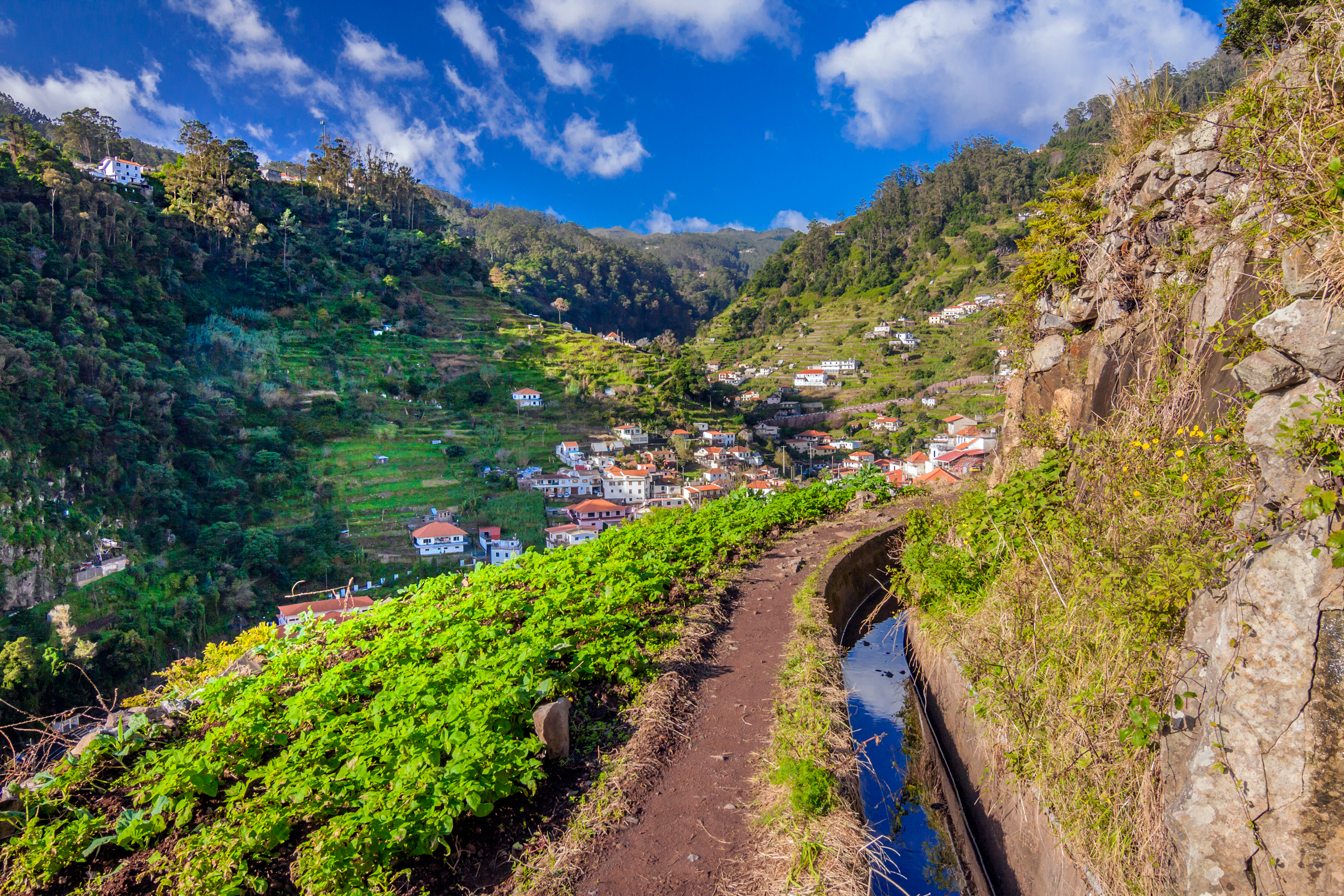 Idyllisk levada-sti på Madeira med vandingskanal og panoramaudsigt over Marocos landsbyen og bjergene