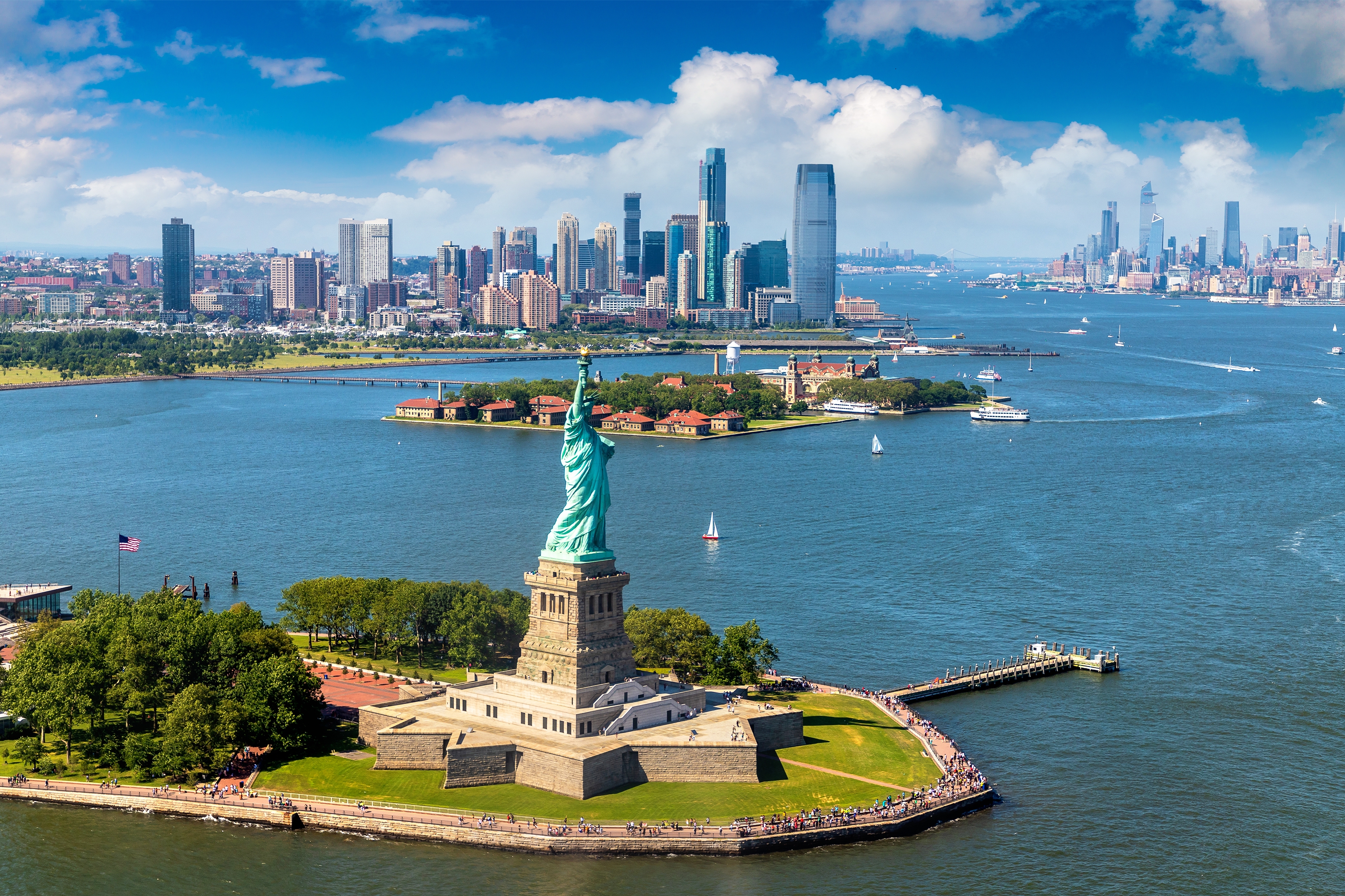 Spektakulært luftfoto af Frihedsgudinden omgivet af New York havnen med Manhattan i baggrunden