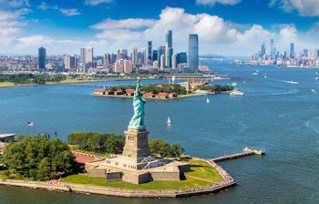 Spektakulært luftfoto af Frihedsgudinden omgivet af New York havnen med Manhattan i baggrunden