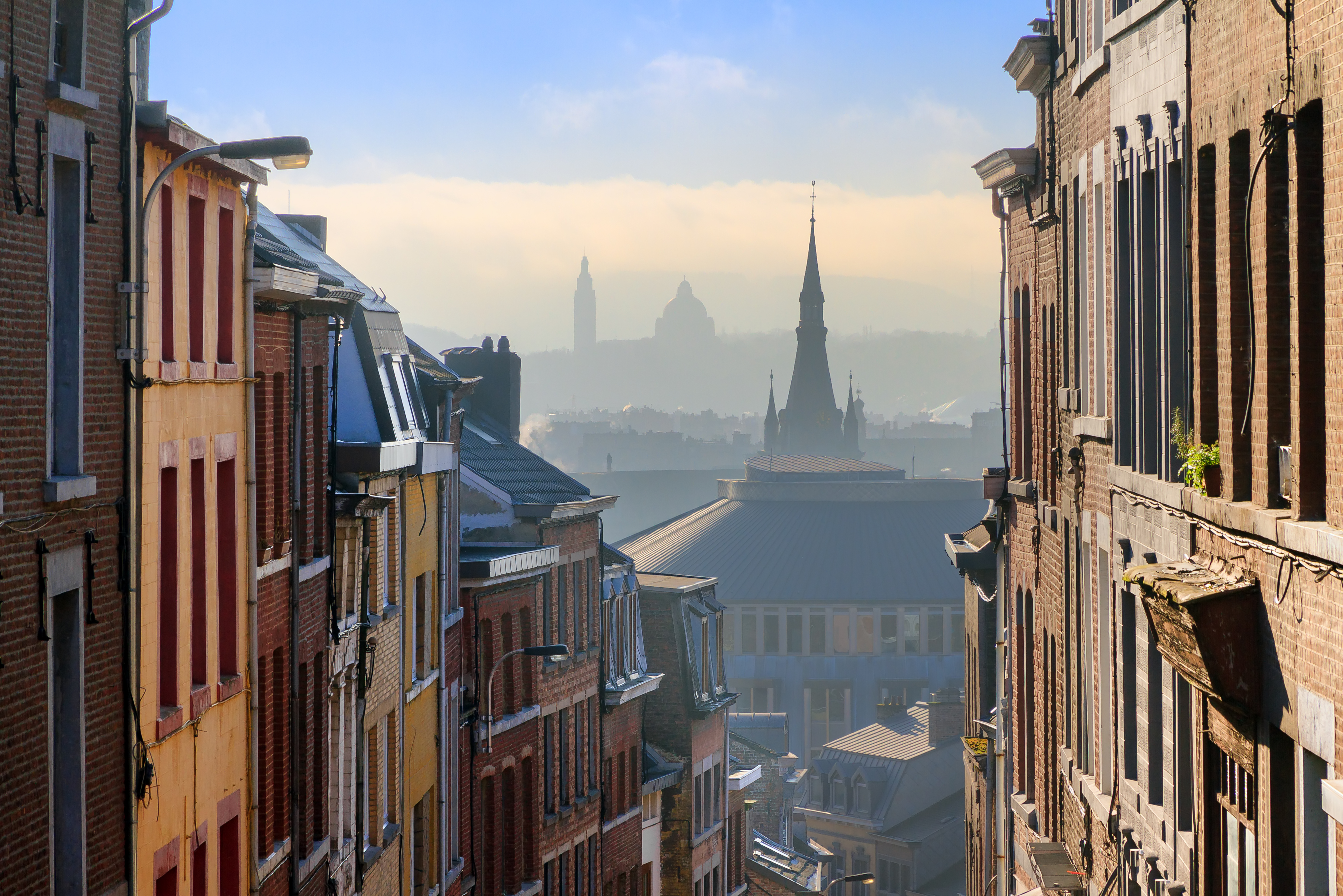 Historisk bykerne i Liège, Belgien, med karakteristiske kirketårne og røde murstenshuse i vinterlys