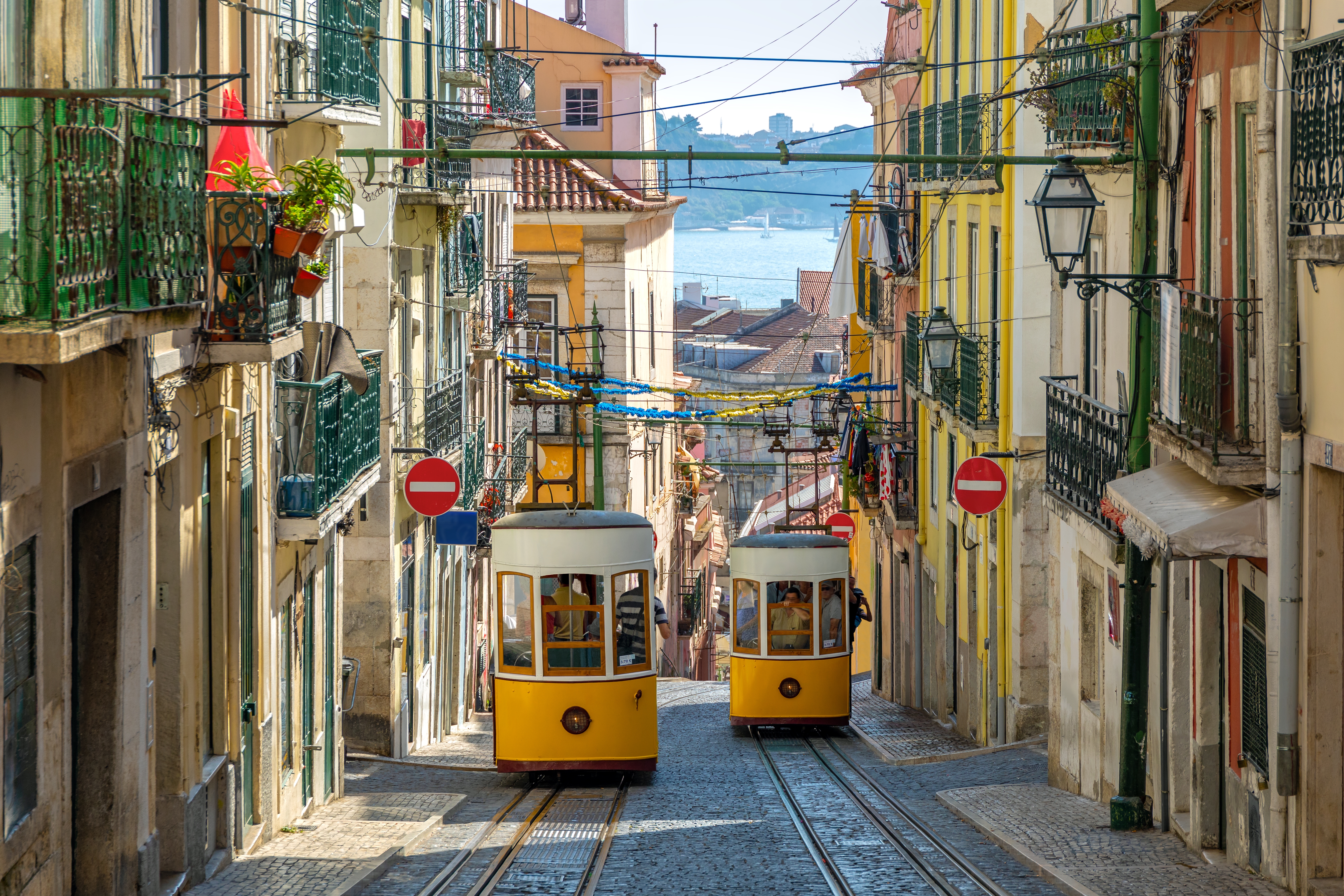Den ikoniske gule Gloria-kabelbane klatrer op ad den stejle gade i Lissabons historiske kvarter, et must-see for besøgende i Portugal