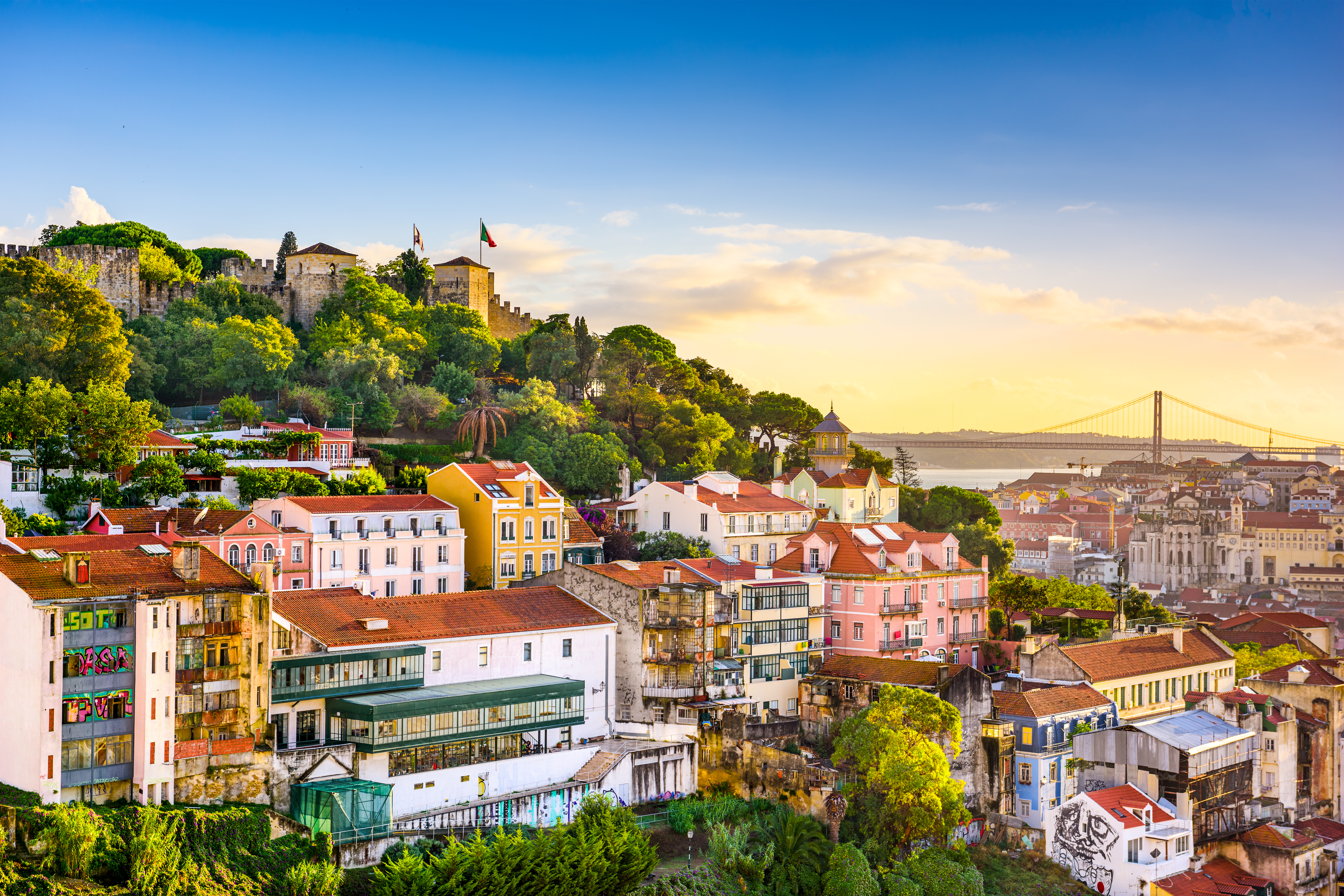 Malerisk udsigt over Lissabons gamle kvarter med traditionelle bygninger og Tagus-floden fotograferet fra det historiske São Jorge-slot