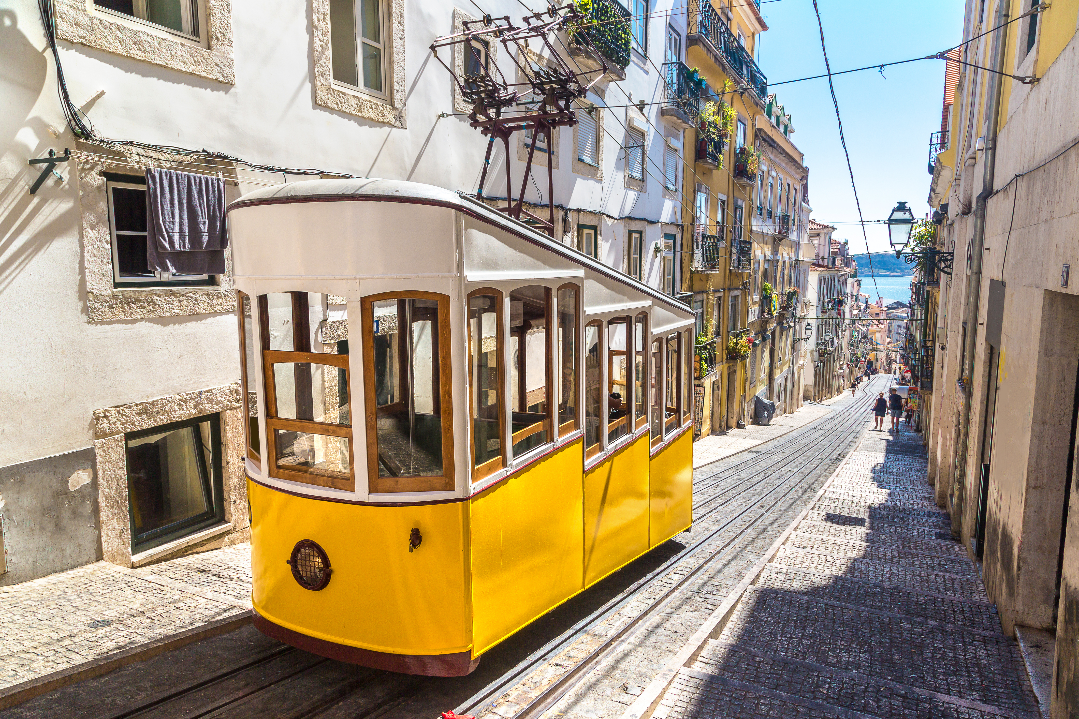 Traditionel gul sporvogn navigerer smalle gader i Lissabon under rejse til Portugal