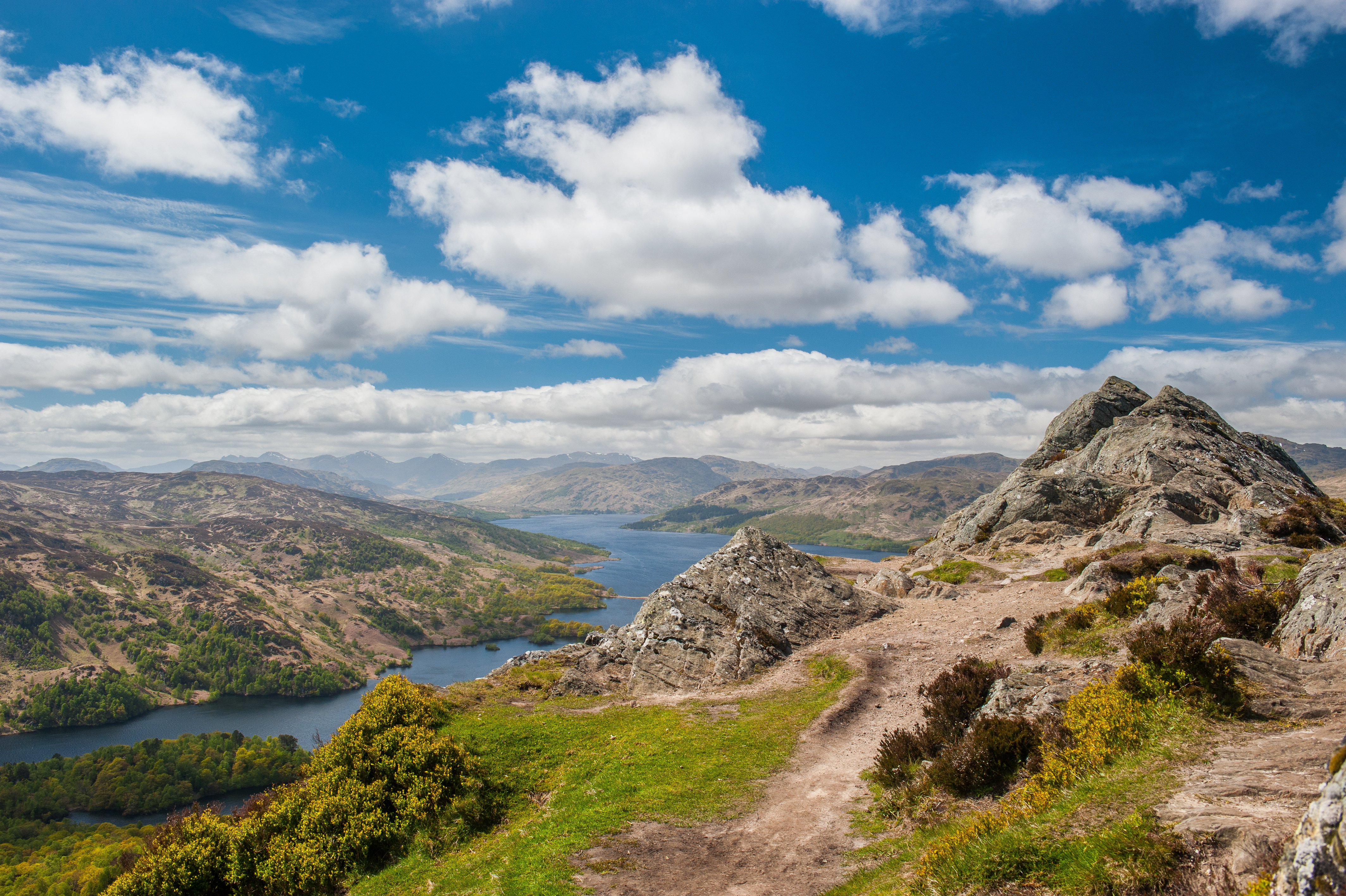 Fantastisk udsigt over Loch Katrine og de skotske højlande fra Ben A'ans top med smuk natur og blå himmel