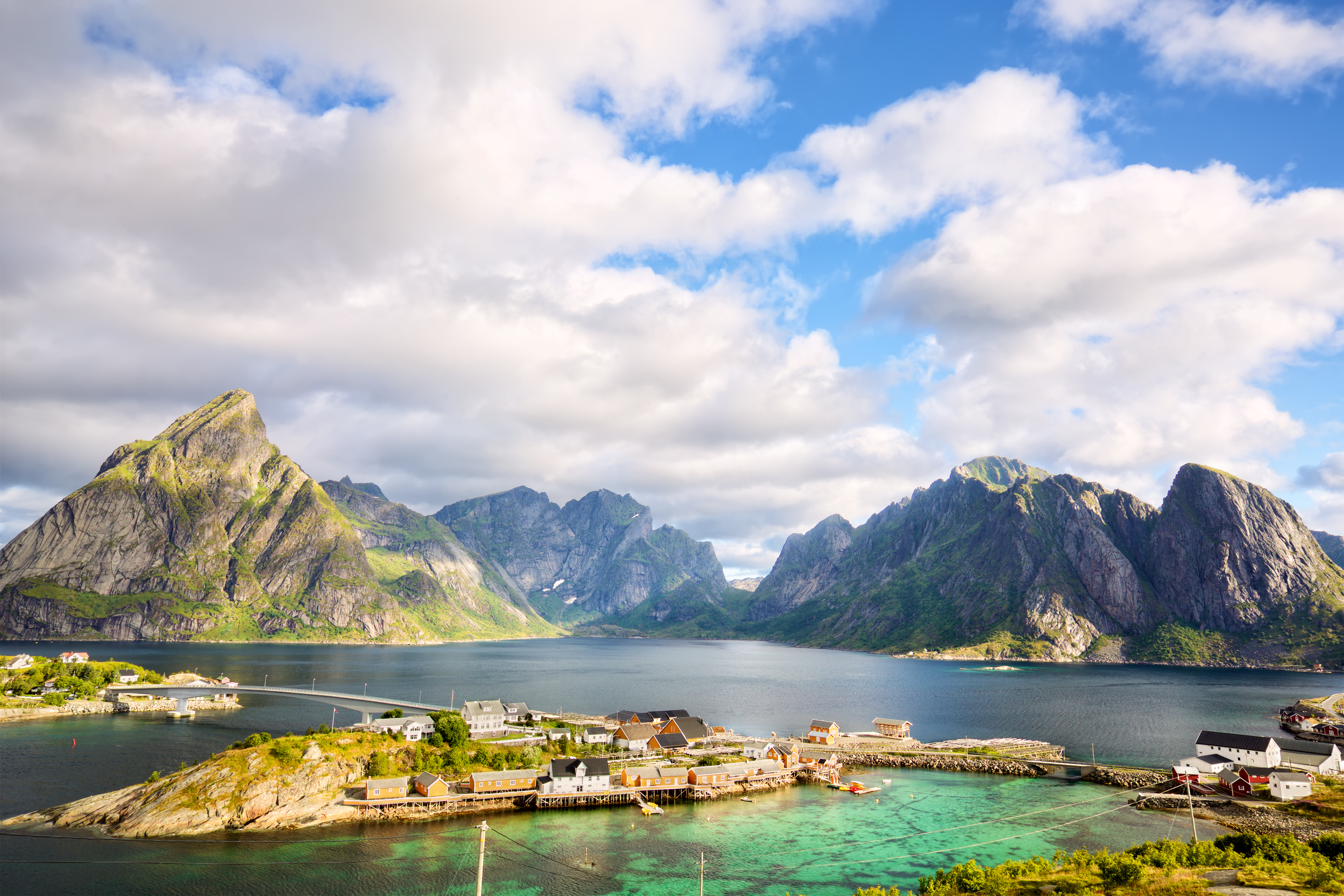 Fantastisk udsigt over den norske fiskerby Reine på Lofoten-øerne med turkist vand, traditionelle huse og høje bjerge