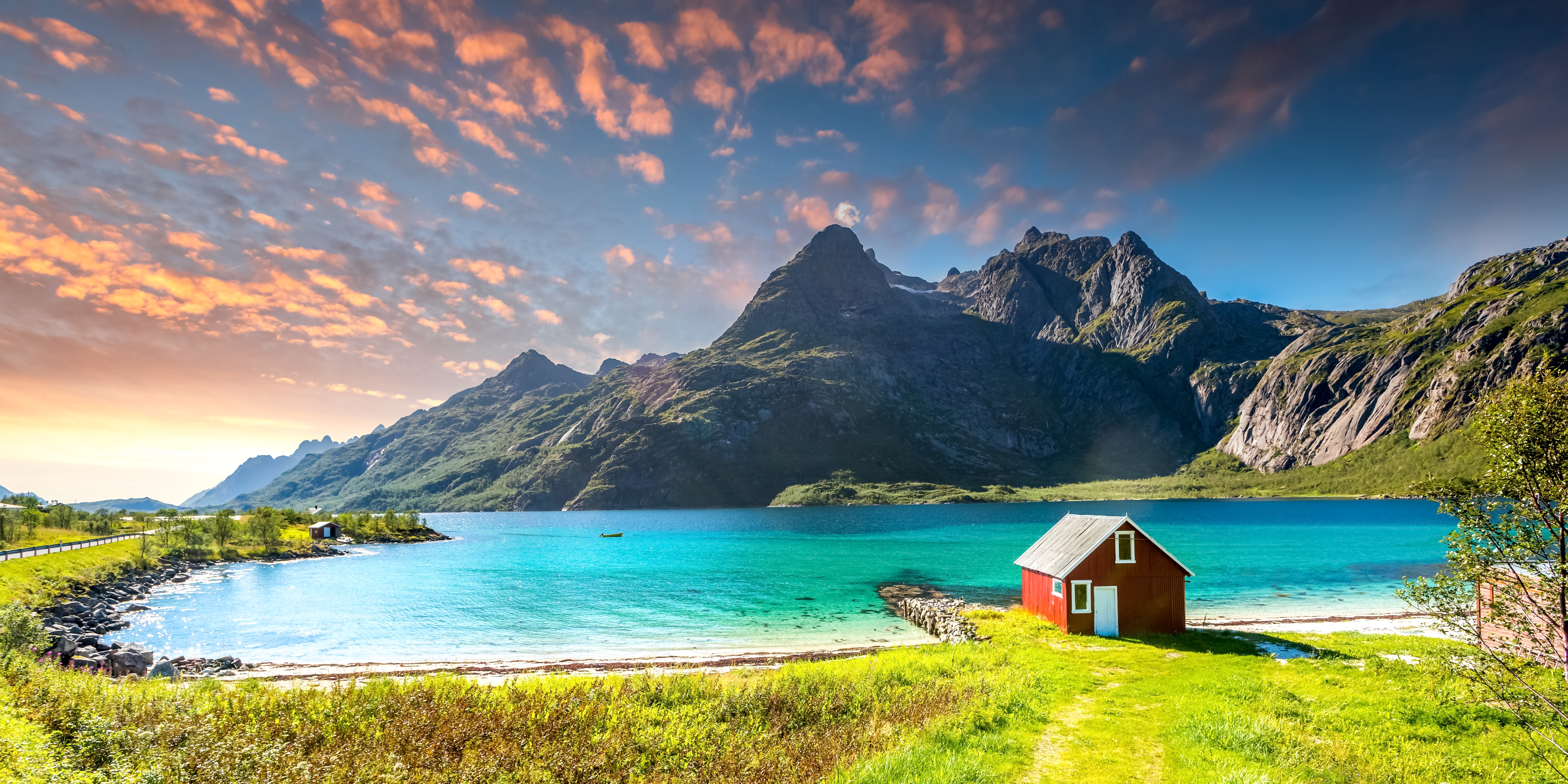 Eventyrligt norsk fjordlandskab ved Trollfjord på Lofoten med karakteristisk rødt rorbu-hus, turkist vand og dramatiske bjerge