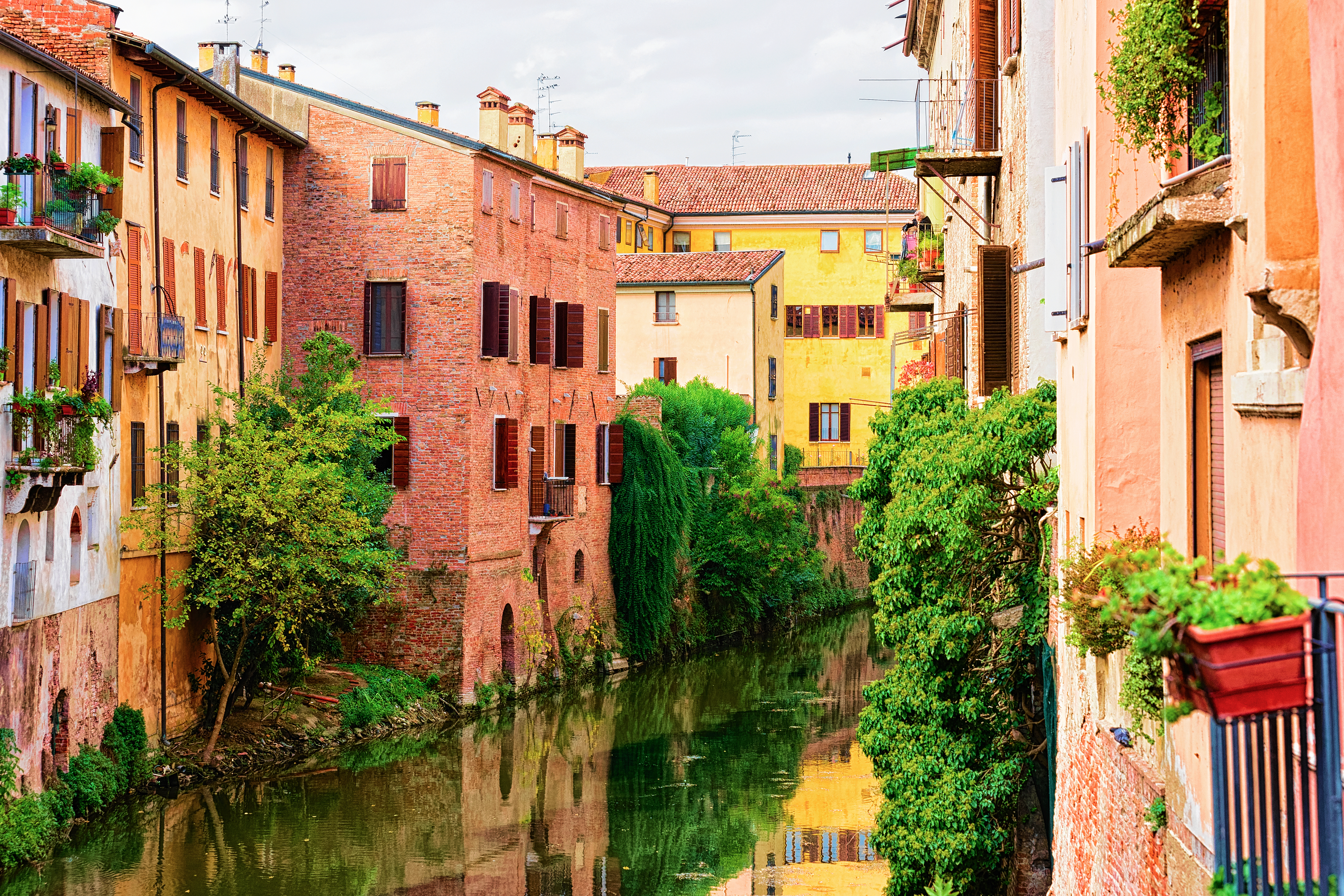 Idyllisk kanalomraade med farverige facade i den historiske by Mantova