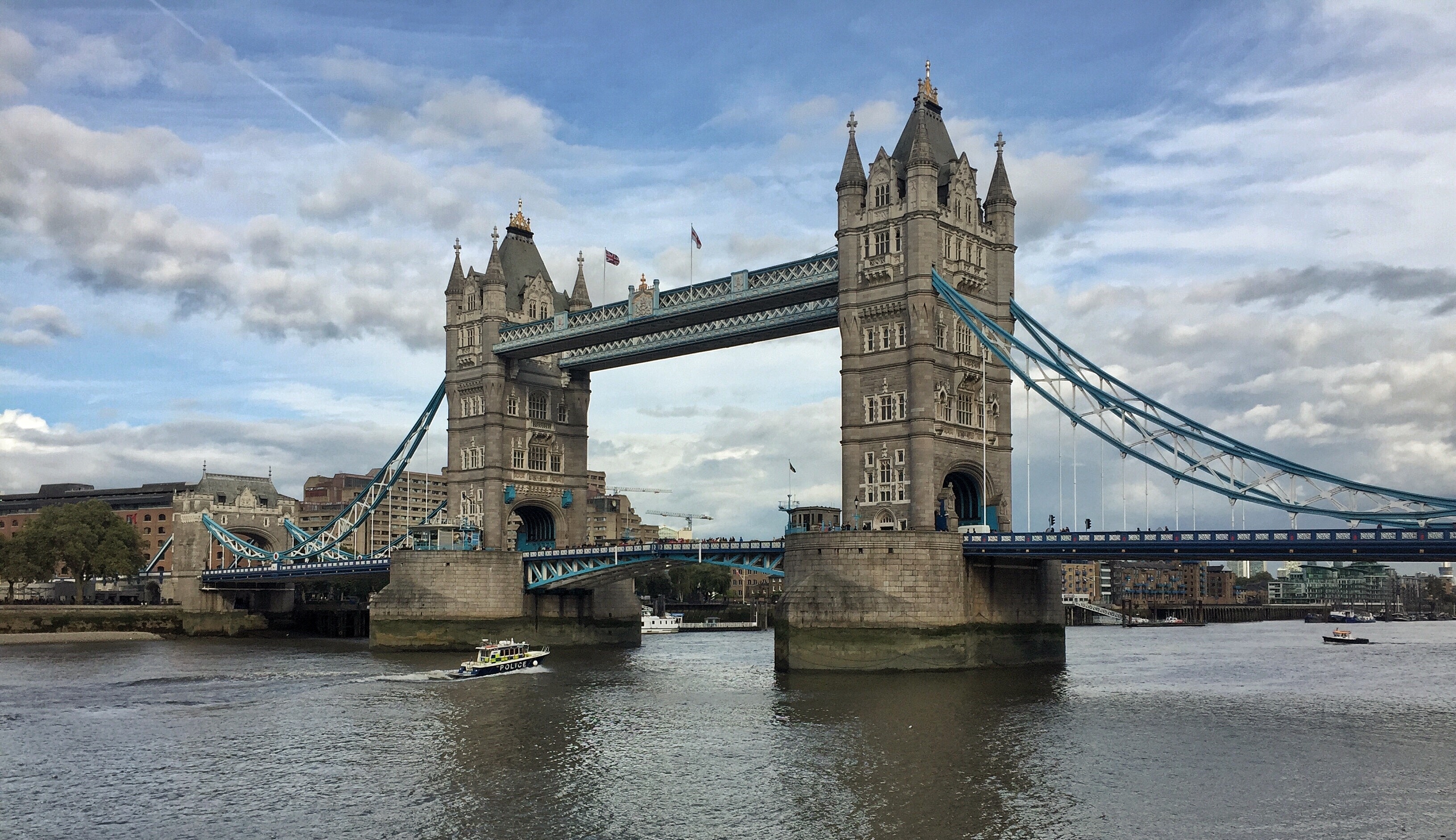 Det berømte Tower Bridge i London spænder over Themsen med klart vand og historiske stentårne under en blå himmel