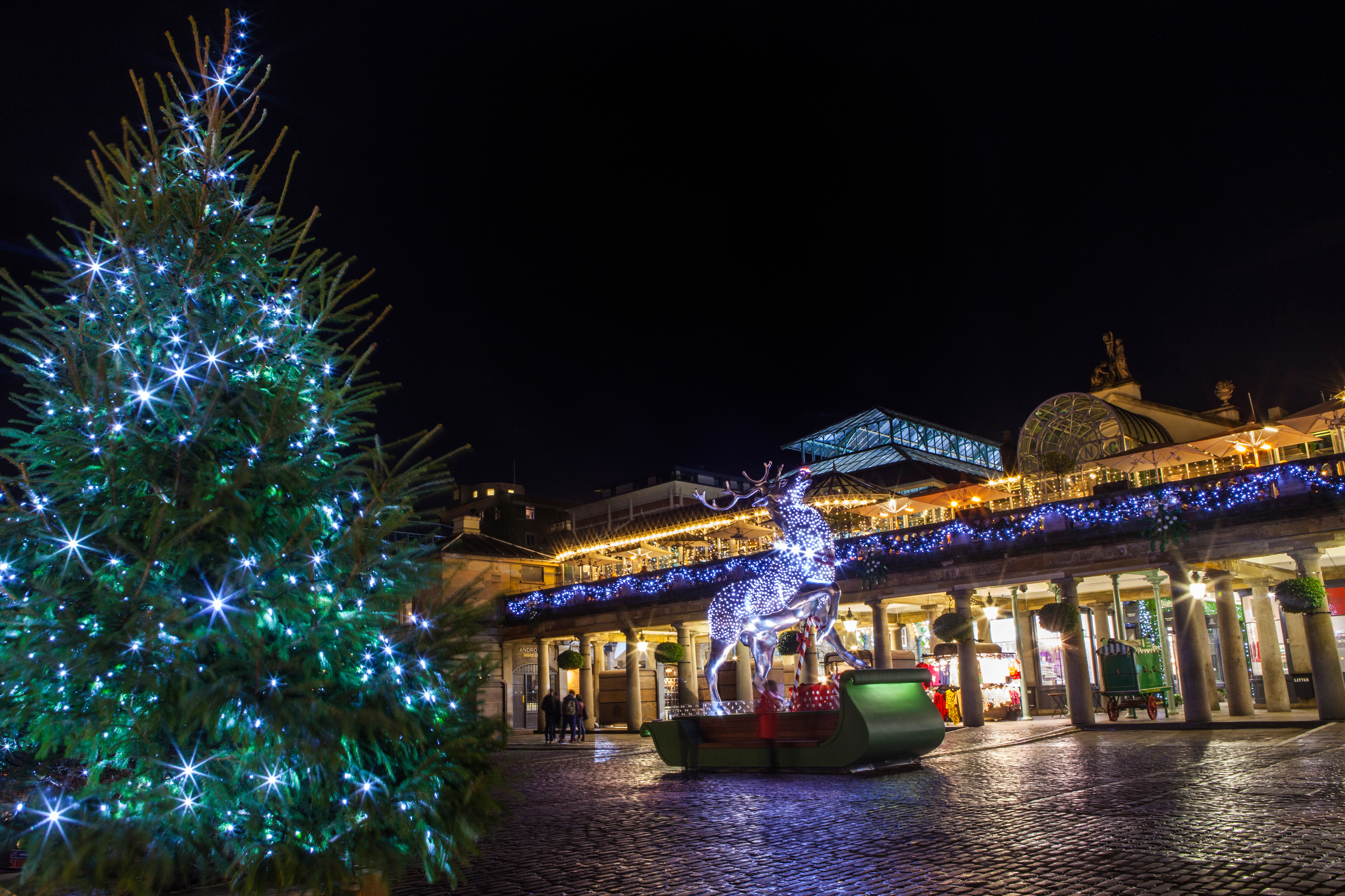 Festlig julestemning ved Covent Garden Market i London med strålende julelys, stort juletræ og lysende rensdyr