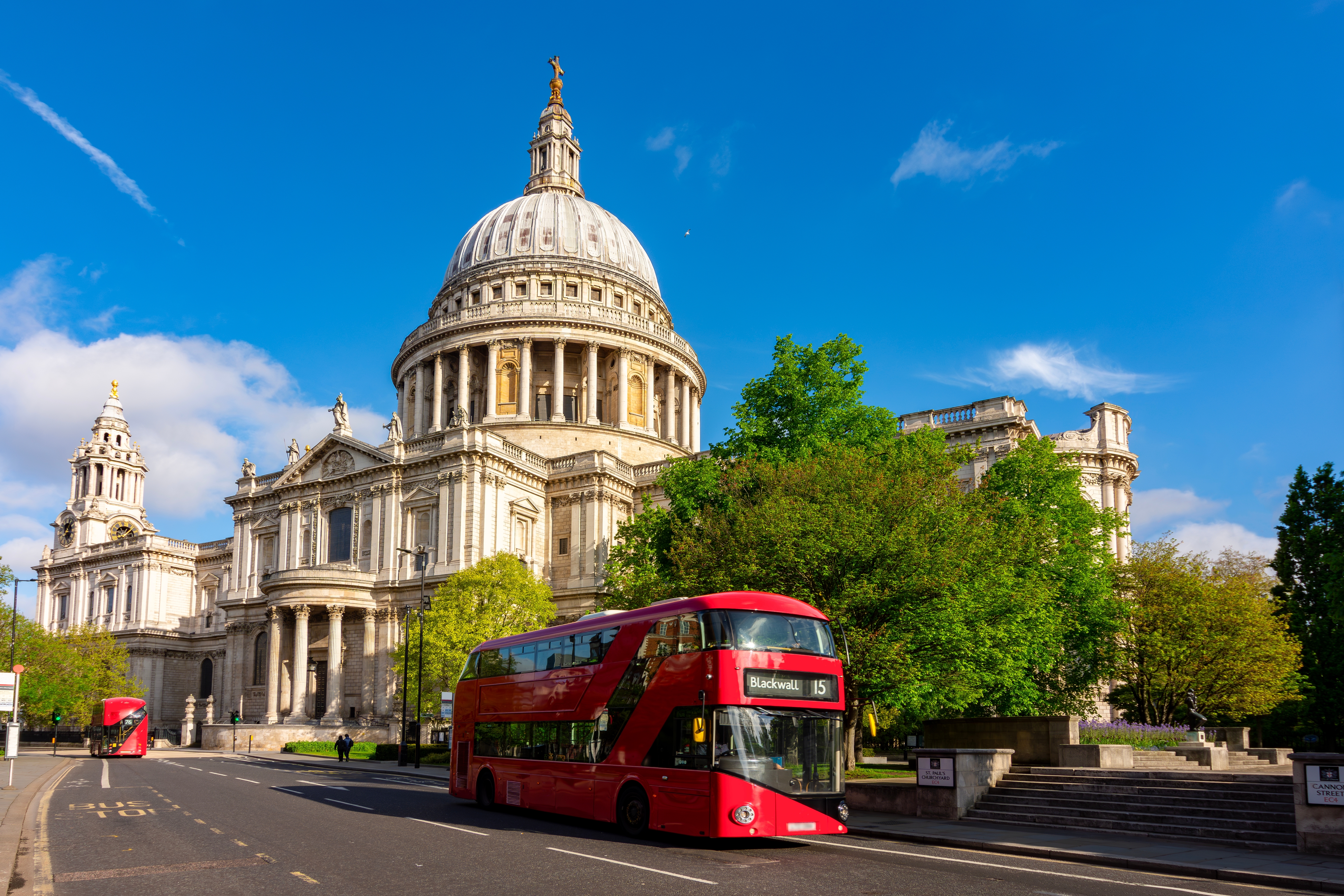 Berømte St. Paul's Cathedral med den karakteristiske kuppel og en klassisk rød dobbeltdækkerbus i London - oplev britisk kultur og historie