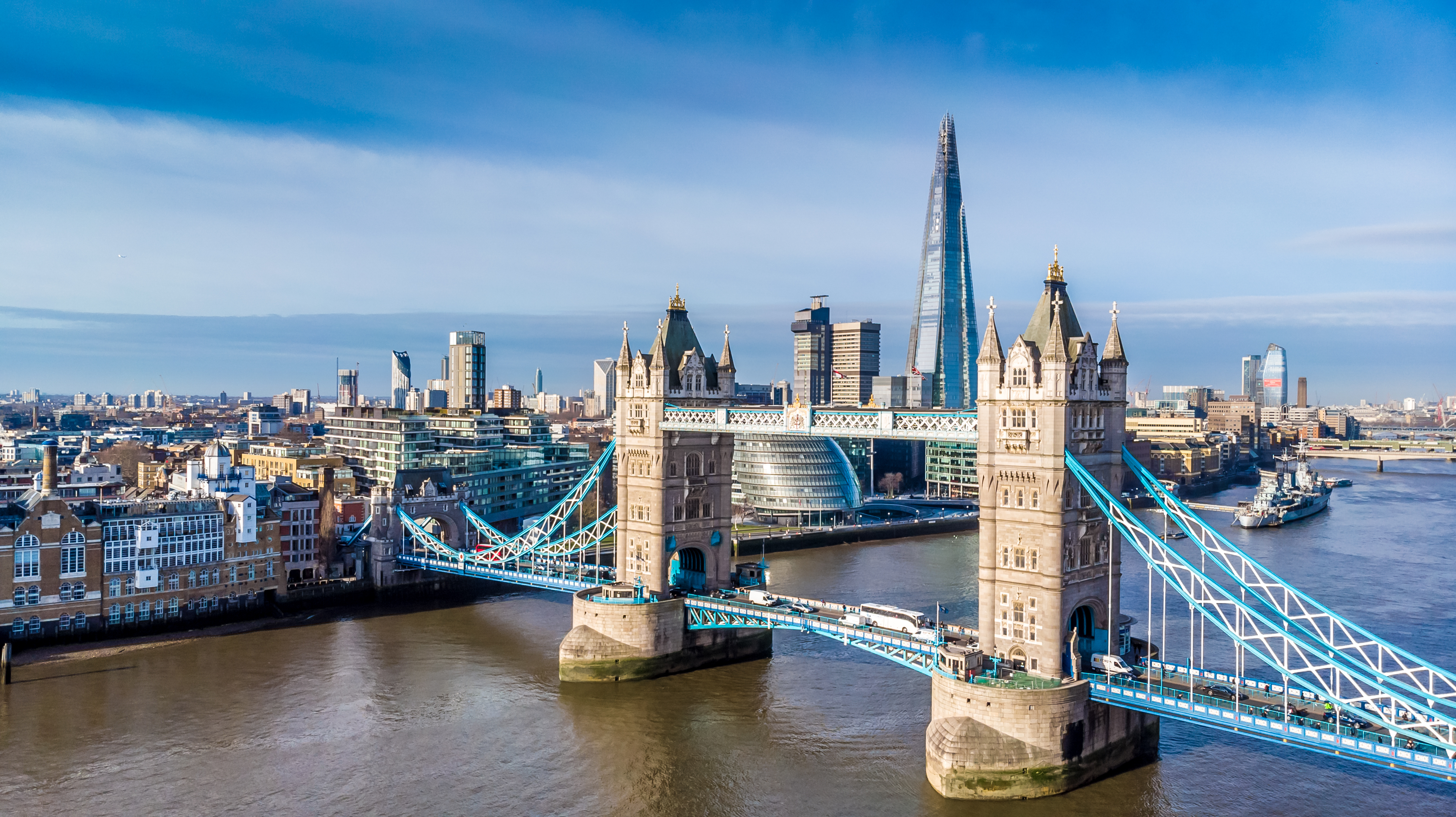 Dronefoto af det historiske Tower Bridge i London med udsigt over Themsen og byens skyline inklusiv The Shard
