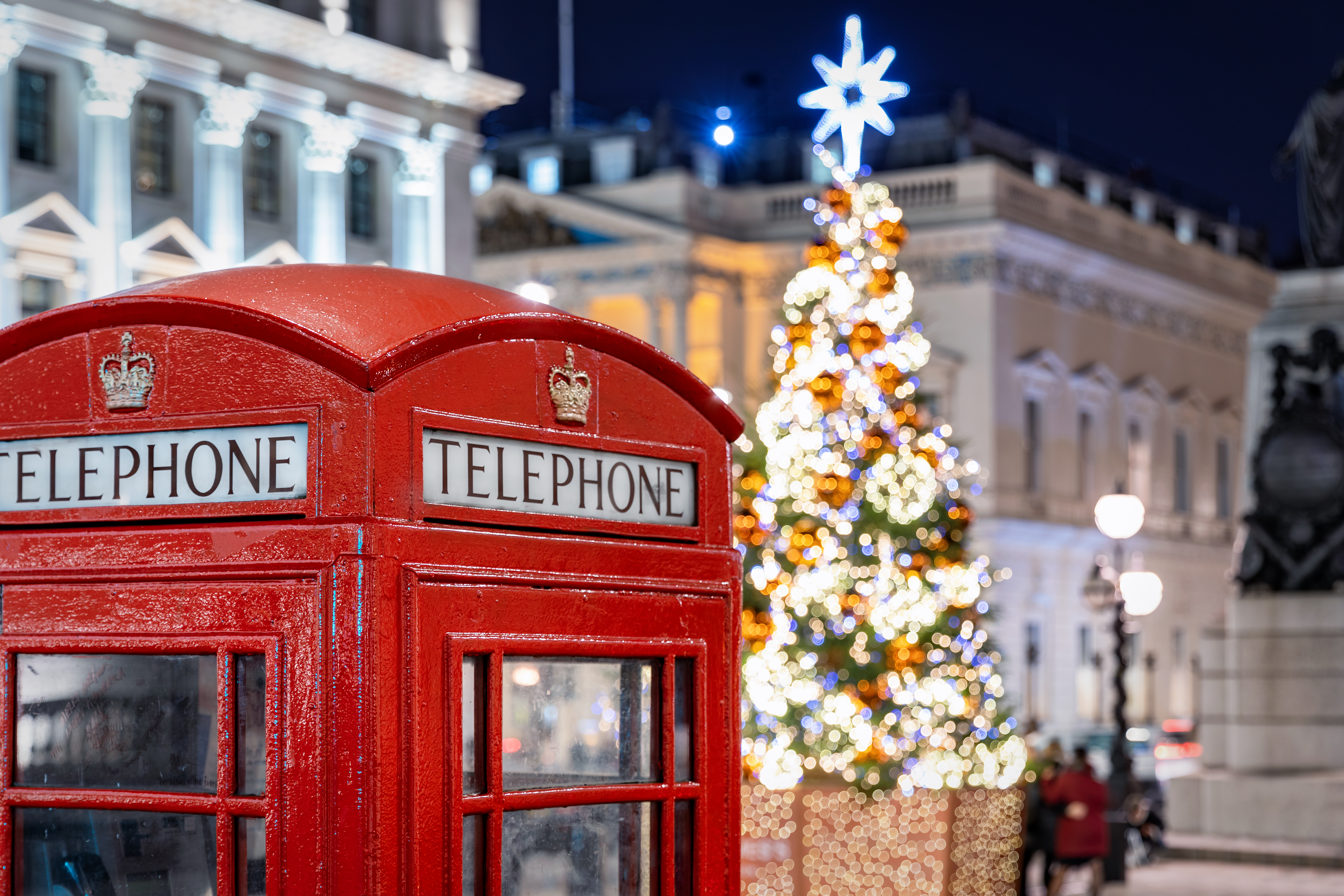 Smuk julestemning i London med røde telefonbokse og et oplyst juletræ om natten