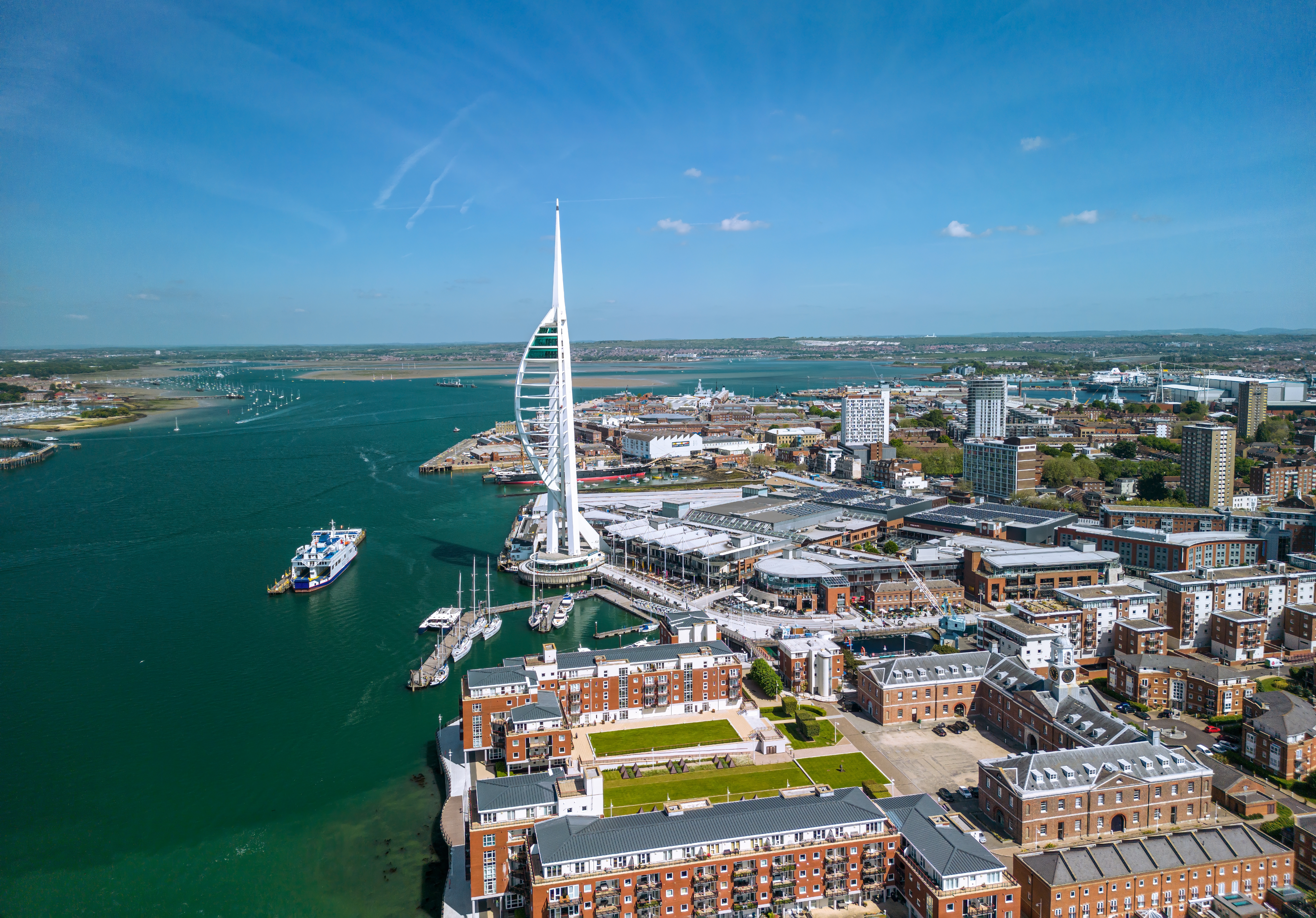 Smuk luftfoto over Portsmouth Harbour og Spinnaker Tower med blå hav og byens skyline i Hampshire, England
