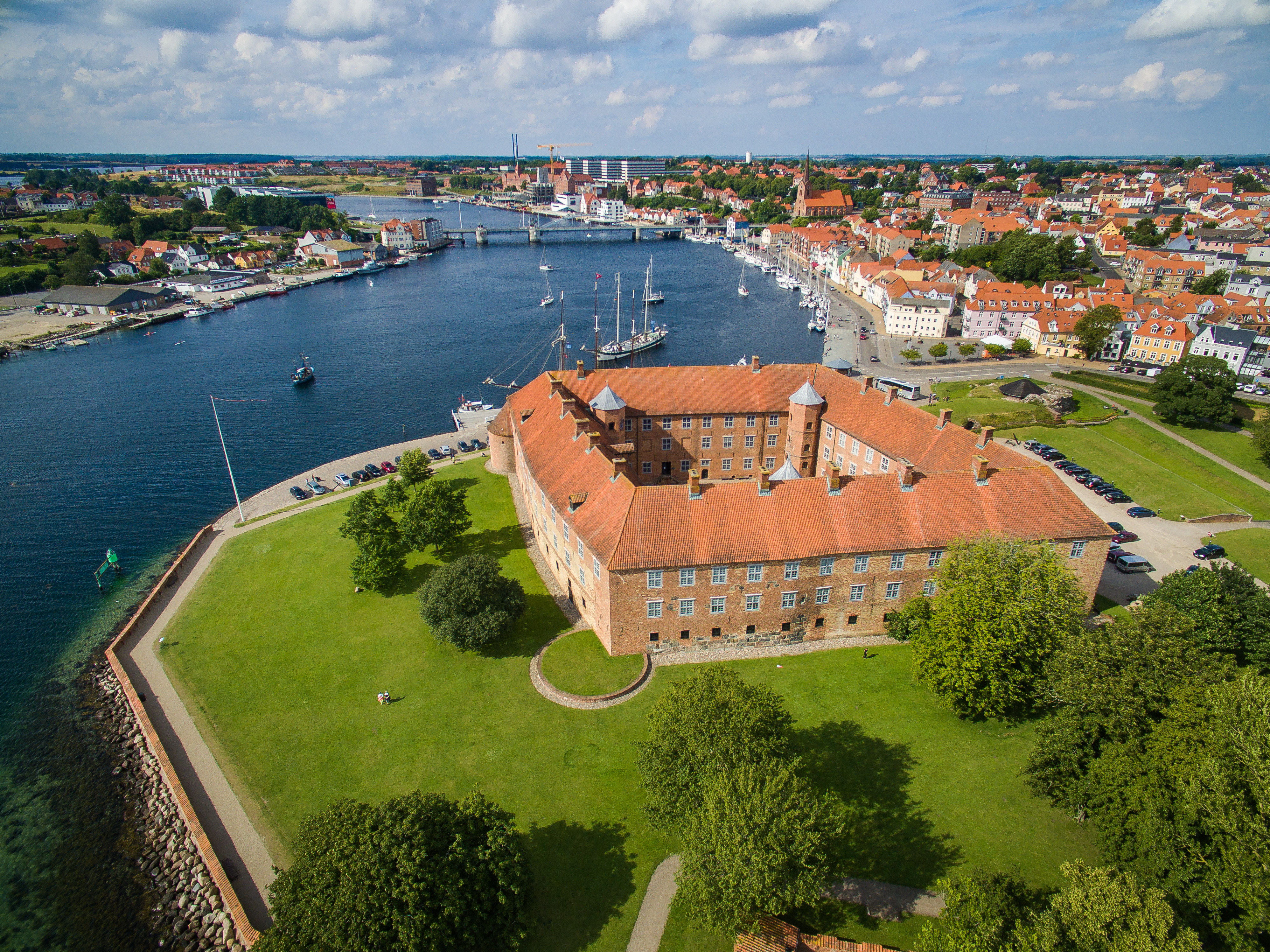 Betagende luftfotografi af Sønderborg Slot set fra oven, der viser den historiske bygning og dens placering ved vandet i Sønderborg