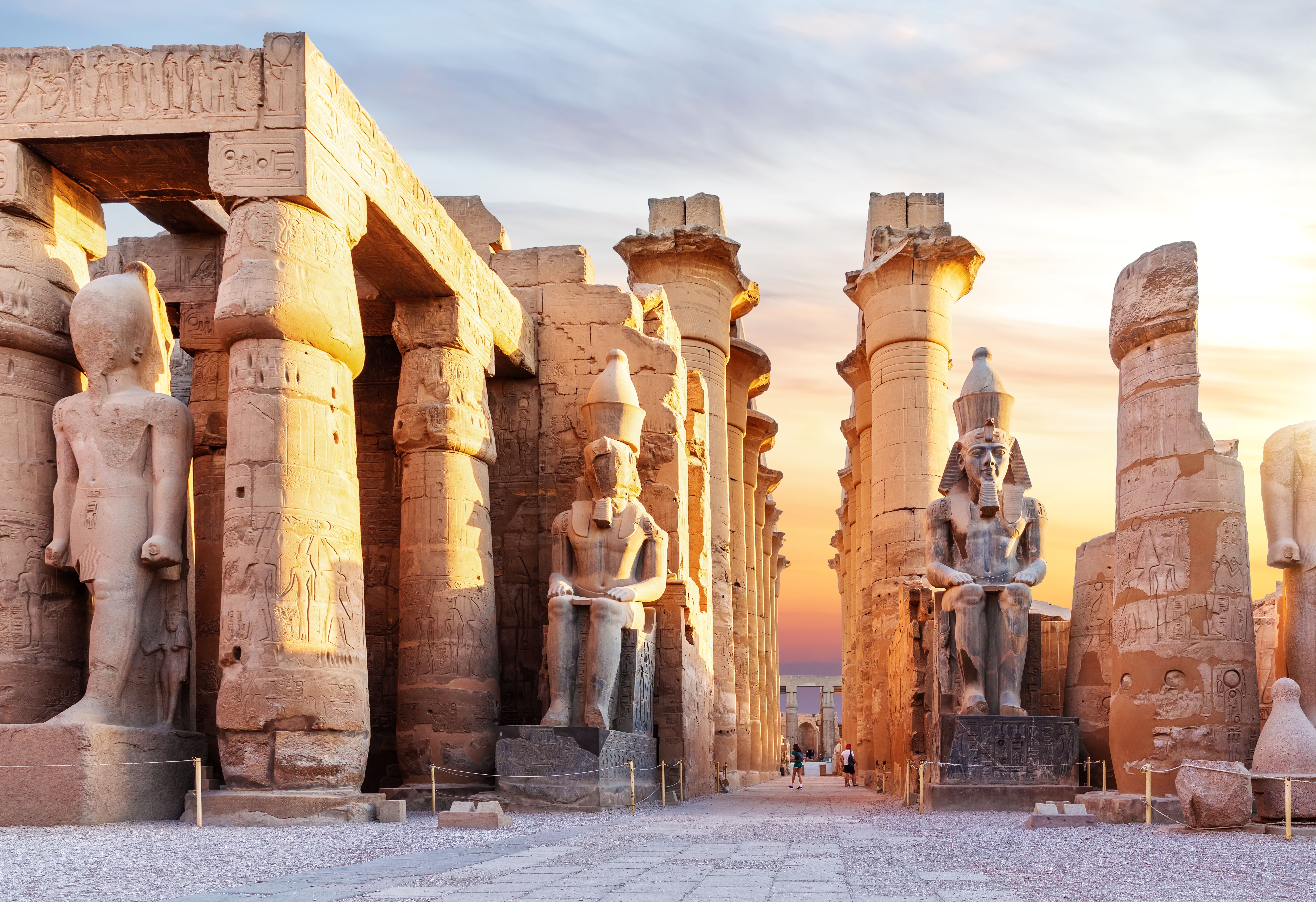 Luxor Templets imponerende kolossalstatuer af Ramses og historiske søjler ved solnedgang i Egypten