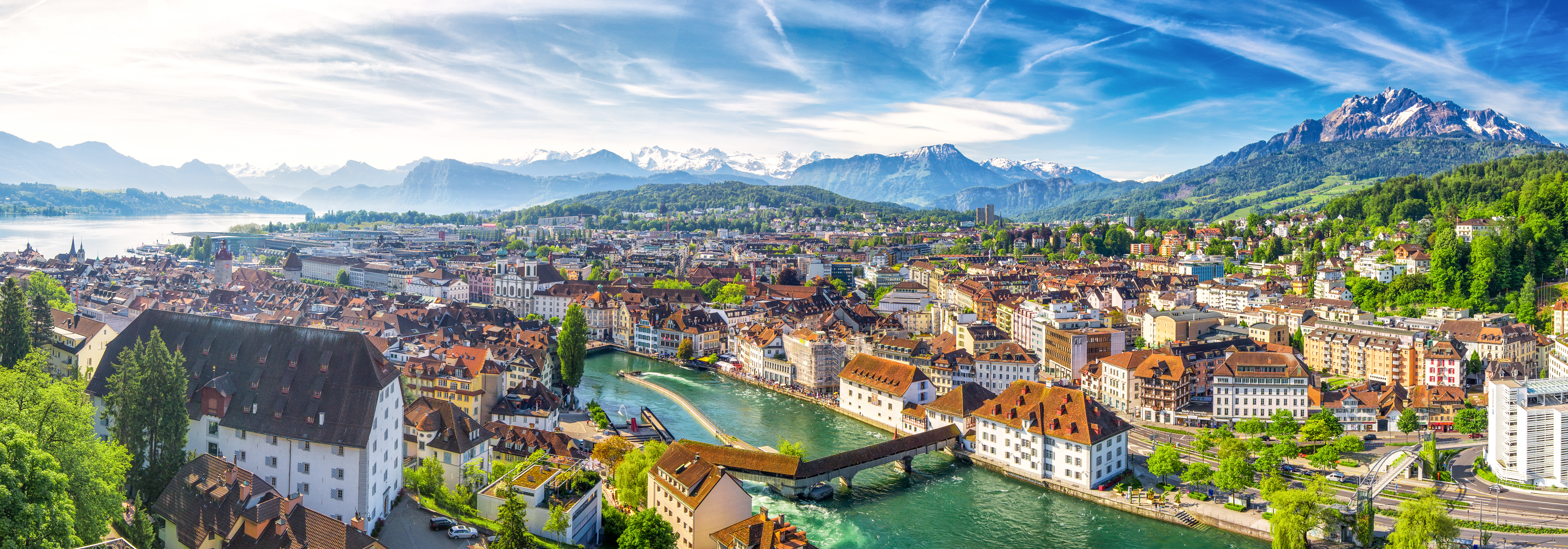Idyllisk udsigt over Luzerns historiske centrum med den berømte træbro, den blå Vierwaldstättersø og de imponerende schweiziske alper