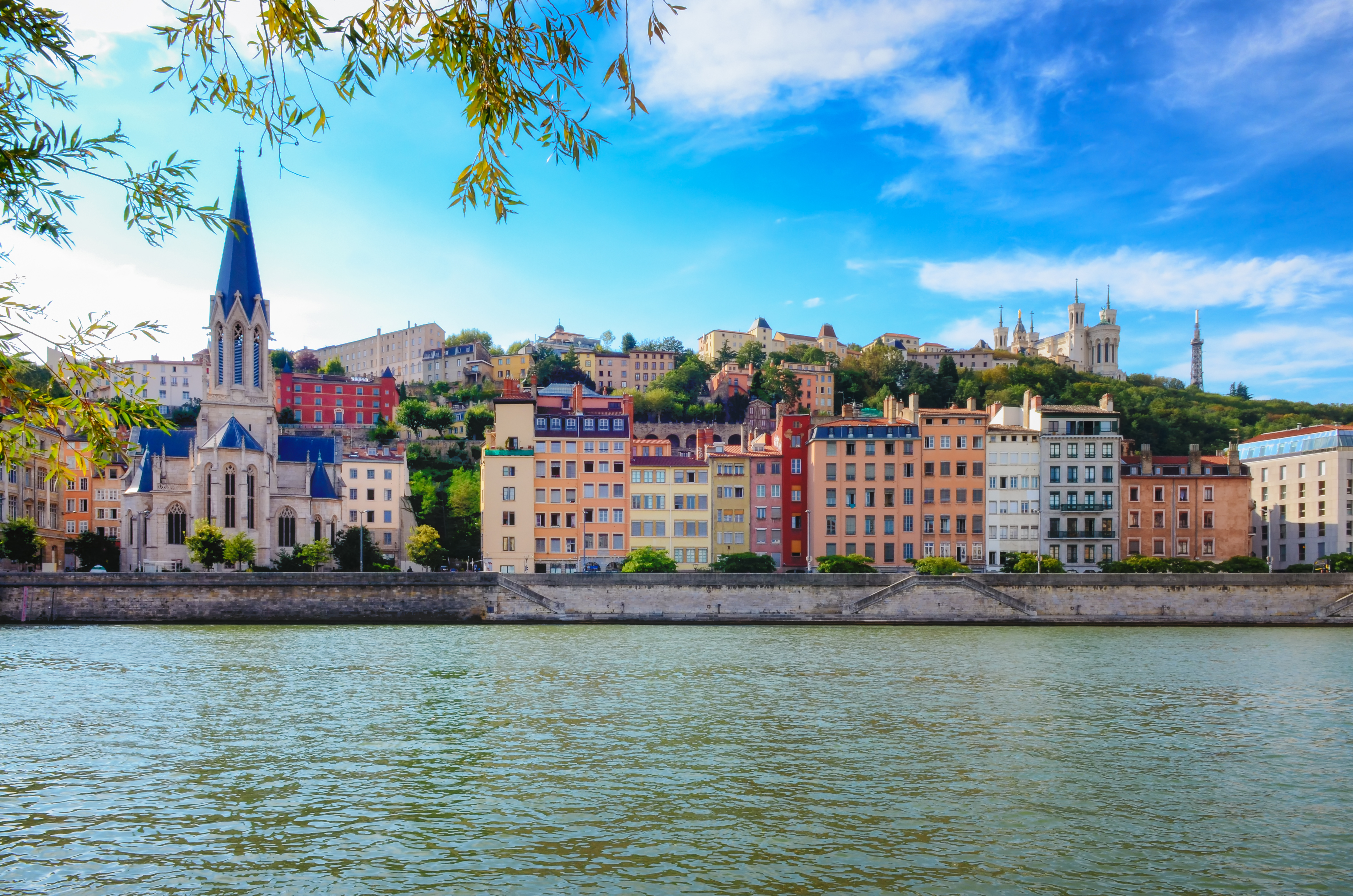 Idyllisk udsigt over Lyons farverige bygninger ved Saône-floden med Fourvière-basilikaen og blå sommerhimmel i Frankrig