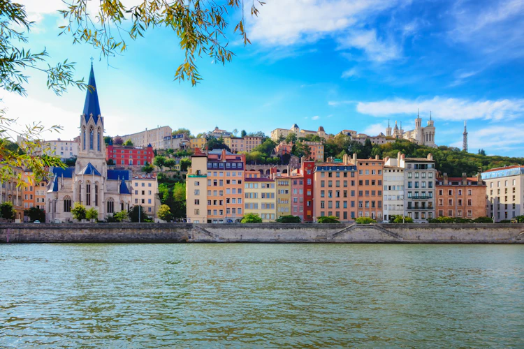 Idyllisk udsigt over Lyons farverige bygninger ved Saône-floden med Fourvière-basilikaen og blå sommerhimmel i Frankrig