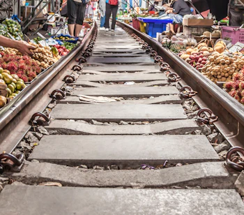 Besøg det berømte Maeklong jernbanemarked i Thailand, hvor lokale handelsmænd sælger eksotiske frugter langs de aktive togspor