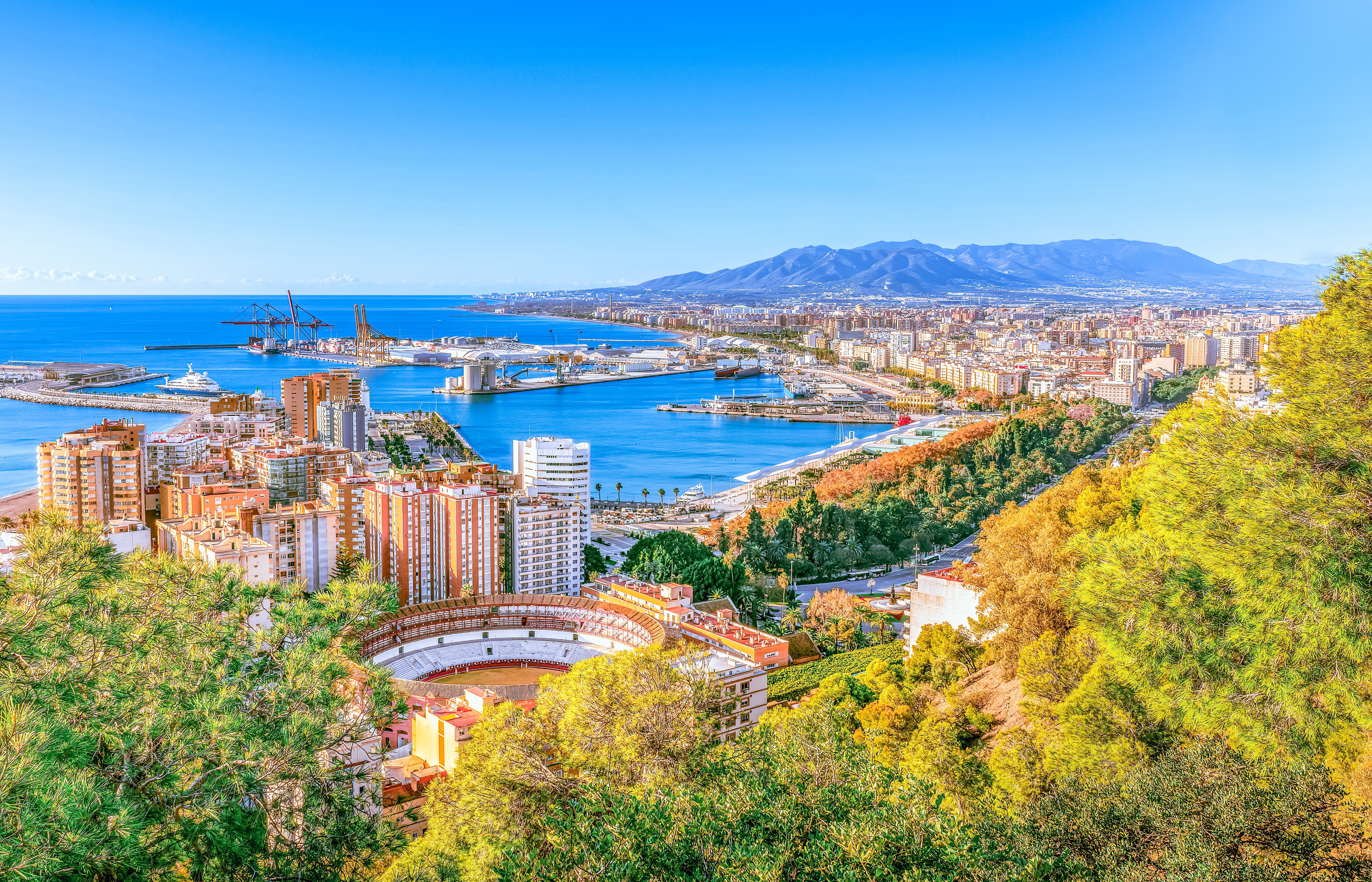 Flot udsigt over Malaga med den historiske tyrekæmpearena, travl havn og det azurblå Middelhav, Costa del Sol