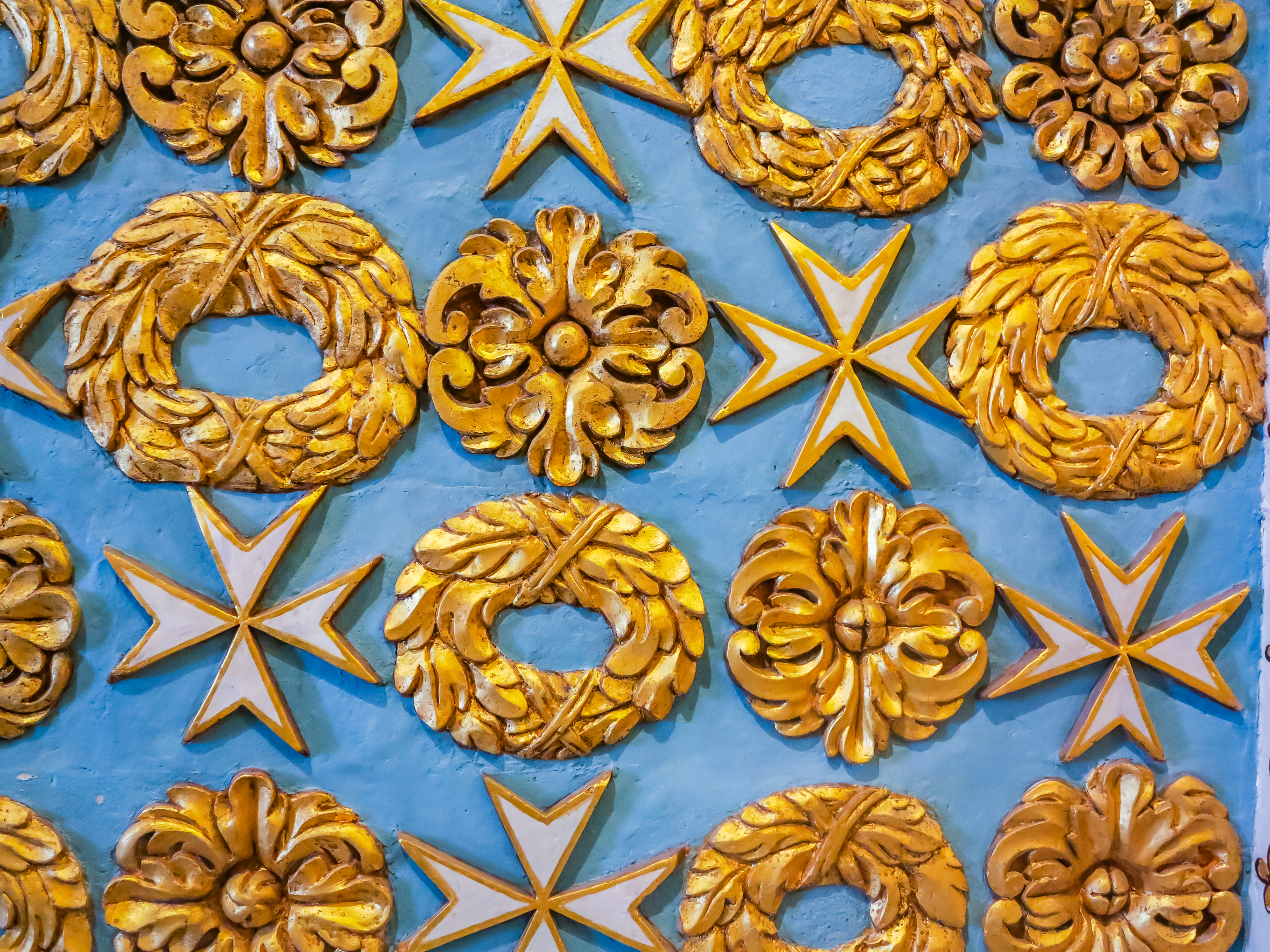 Smukke gyldne Malteserkors og ornamentale blomsterdekorationer på blå baggrund i St. John's Co-Cathedral, Malta