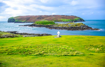 Spektakulær kystlinje på Isle of Man med frodige grønne marker og stenede øer