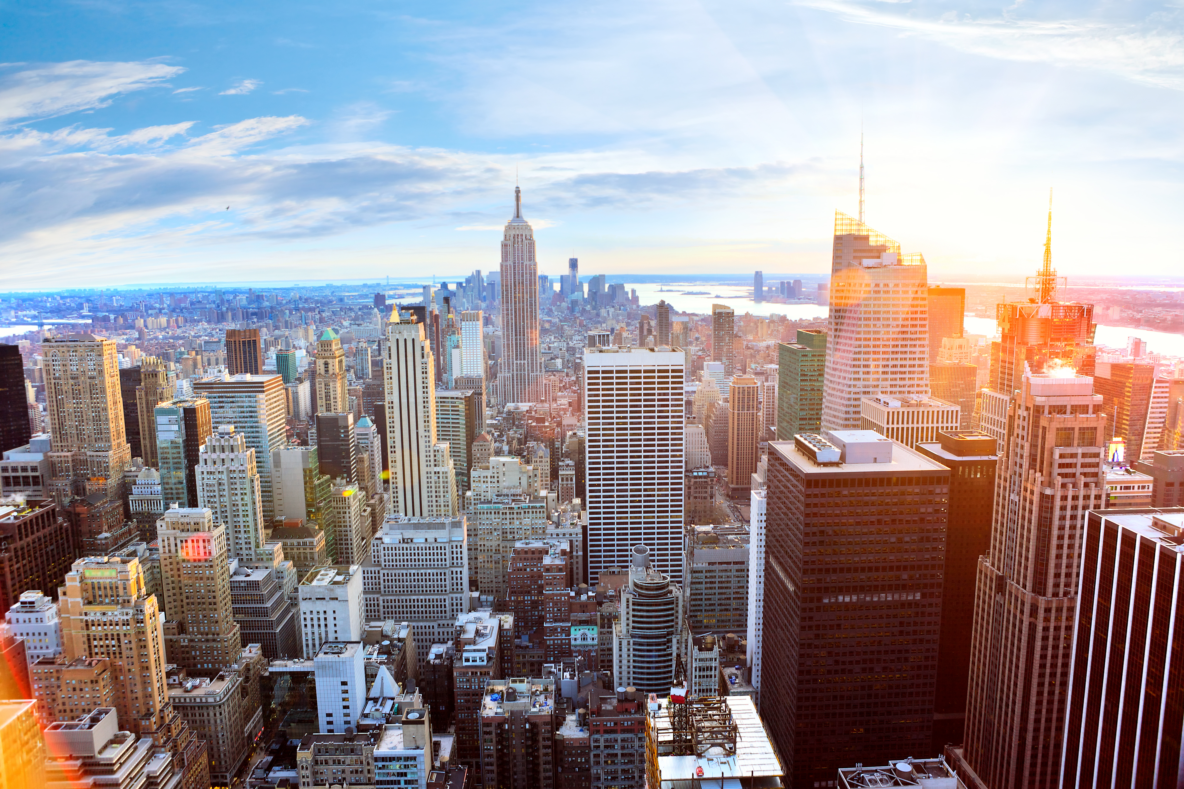 Manhattan skyskrabere i New York ved gyldent solnedgangslys med byens skyline