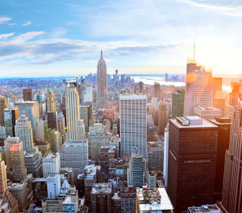 Manhattan skyskrabere i New York ved gyldent solnedgangslys med byens skyline