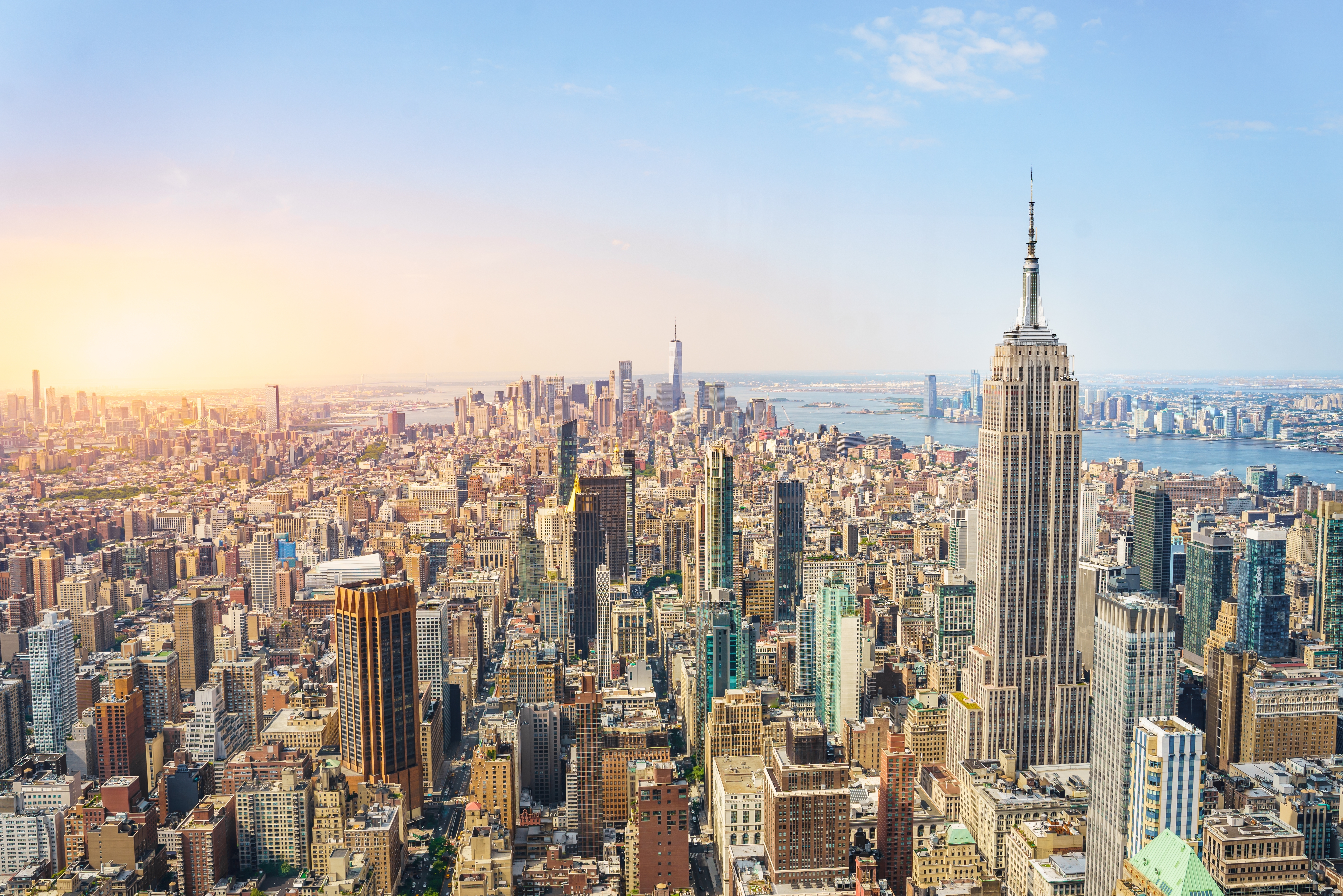 Fascinerende udsigt over New Yorks urbane skyline med Manhattans ikoniske skyskrabere i solnedgangens gyldne skær