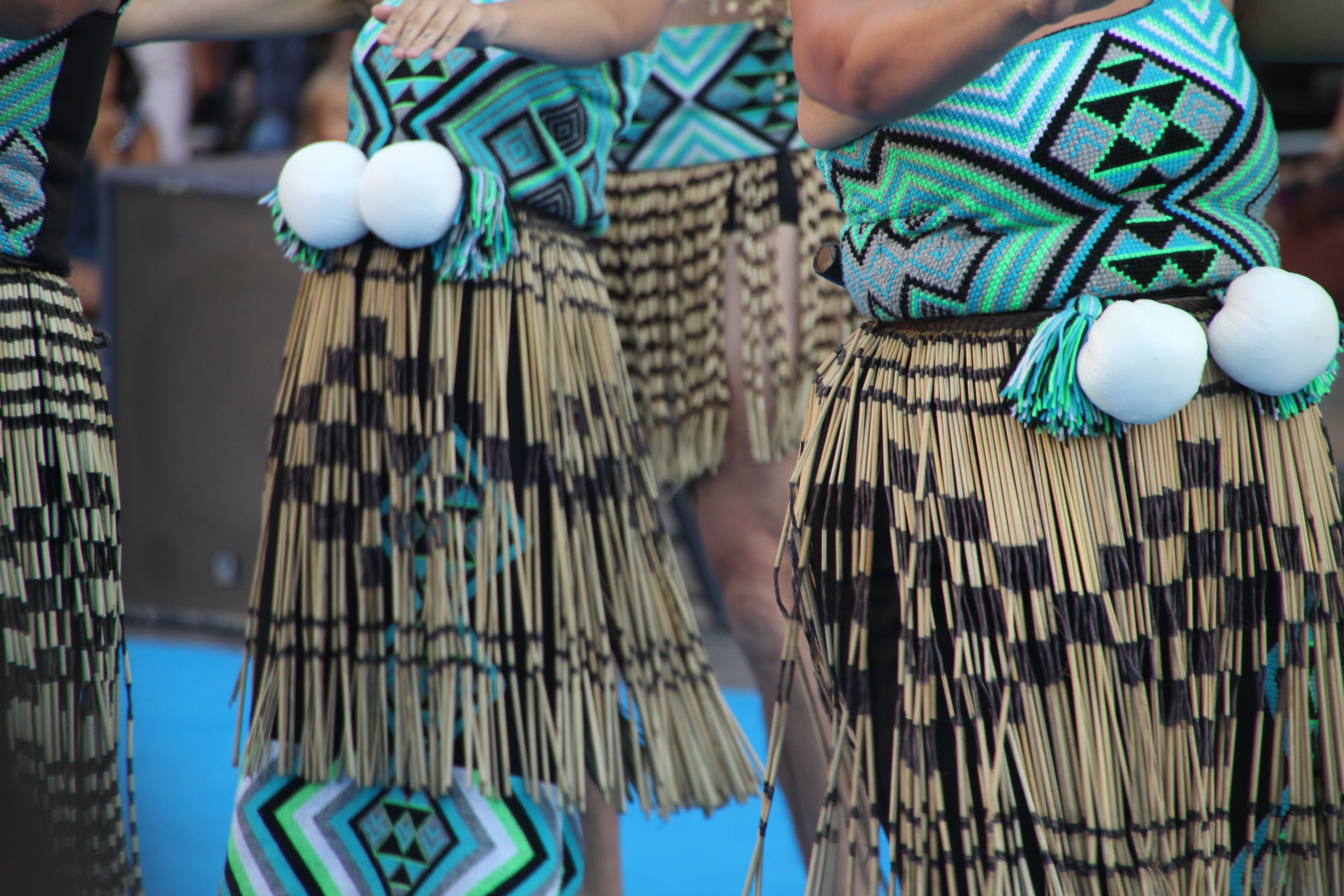 Traditionelle maori-dansere fra New Zealand i farverige vævede dragter med flækskørter og poi-bolde under kulturel festival