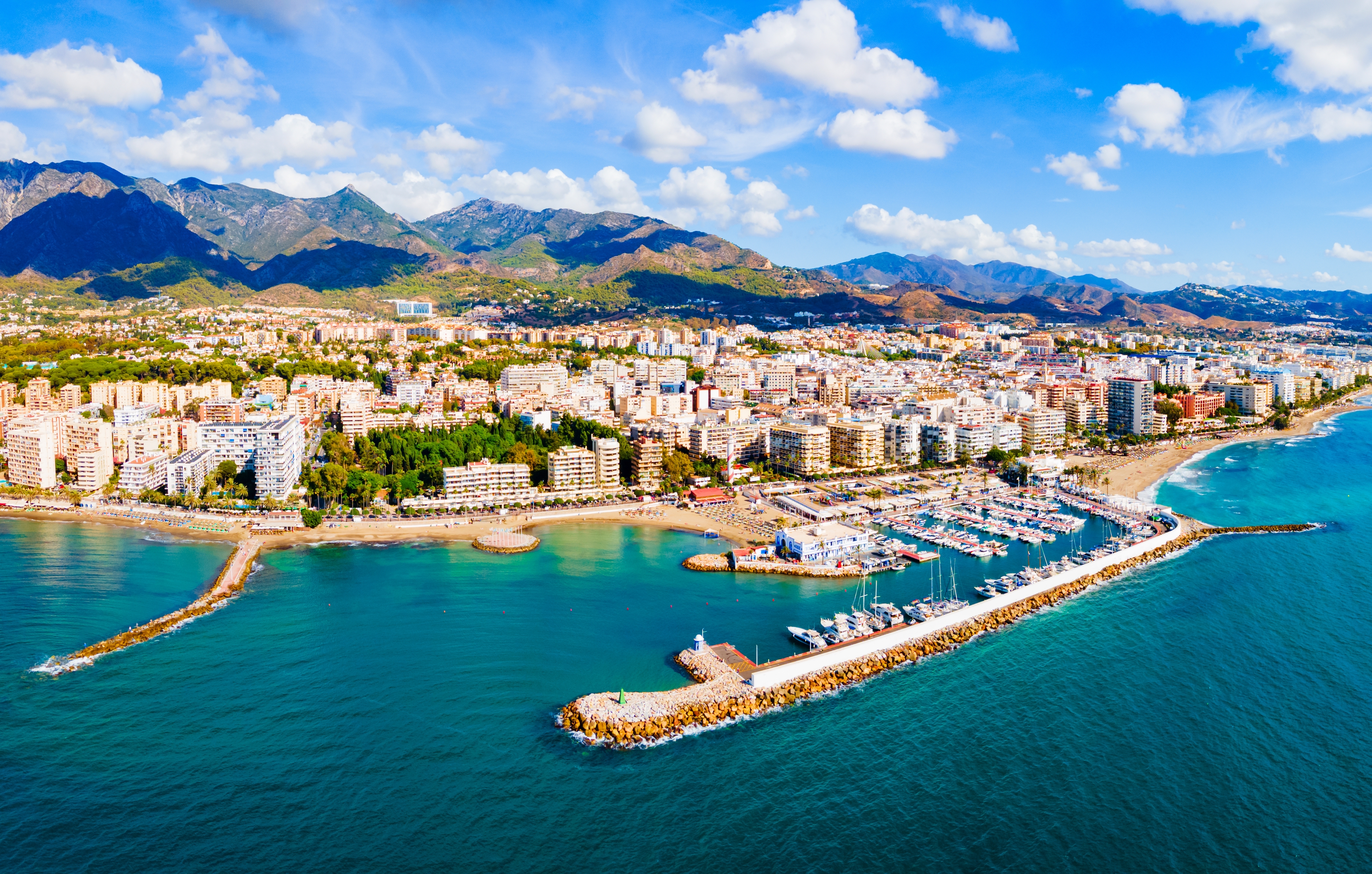 Smuk udsigt over Marbella marina og kystby med bjerge Costa del Sol