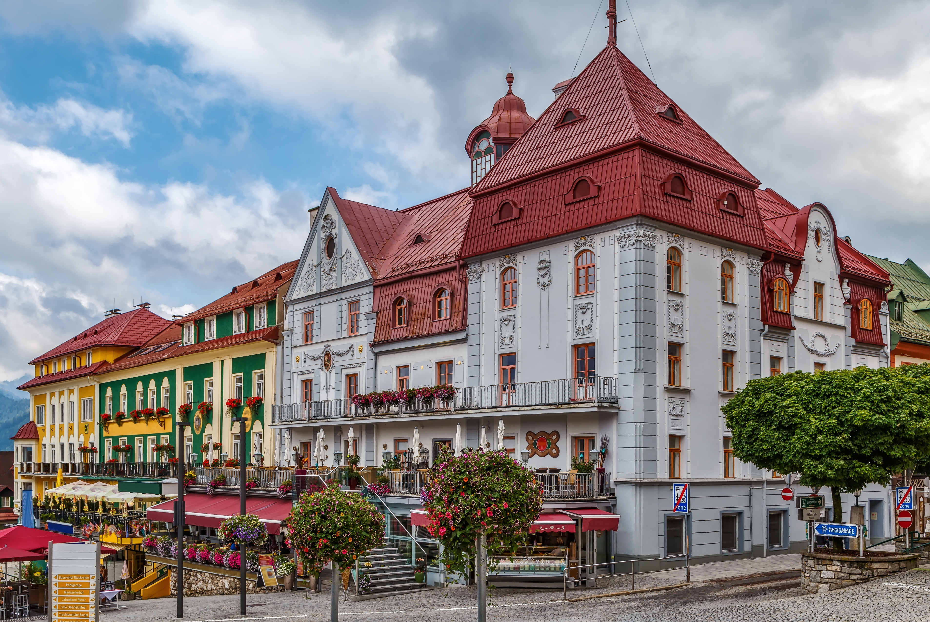 Charmerende bymidte i Mariazell, Østrig med smukke historiske bygninger, røde tage og blomster på balkoner i Styria