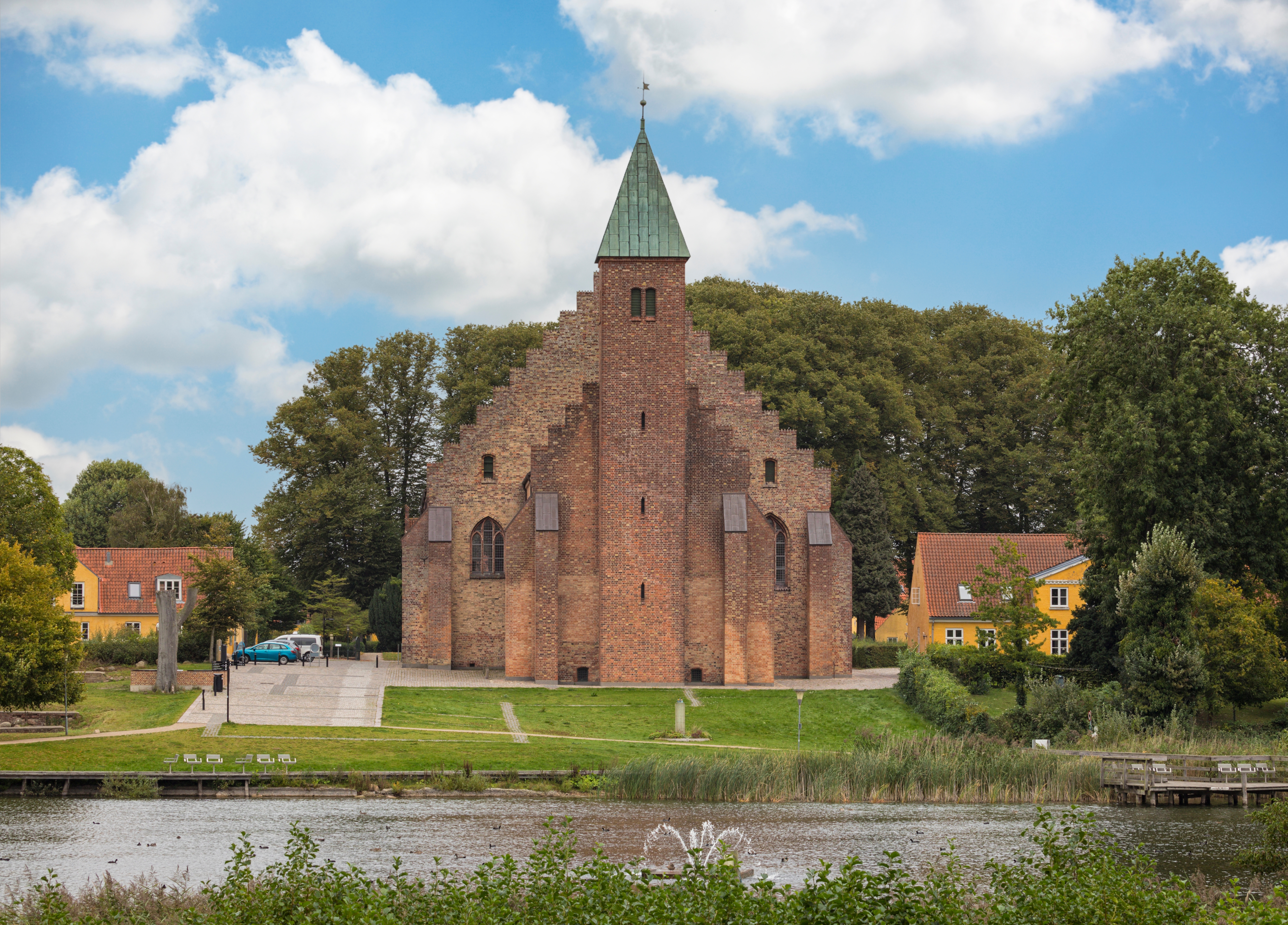 Maribo Domkirke med sin karakteristiske teglstensfacade og Hunså-floden i forgrunden - et historisk gotisk bygningsværk og vartegn på Lolland