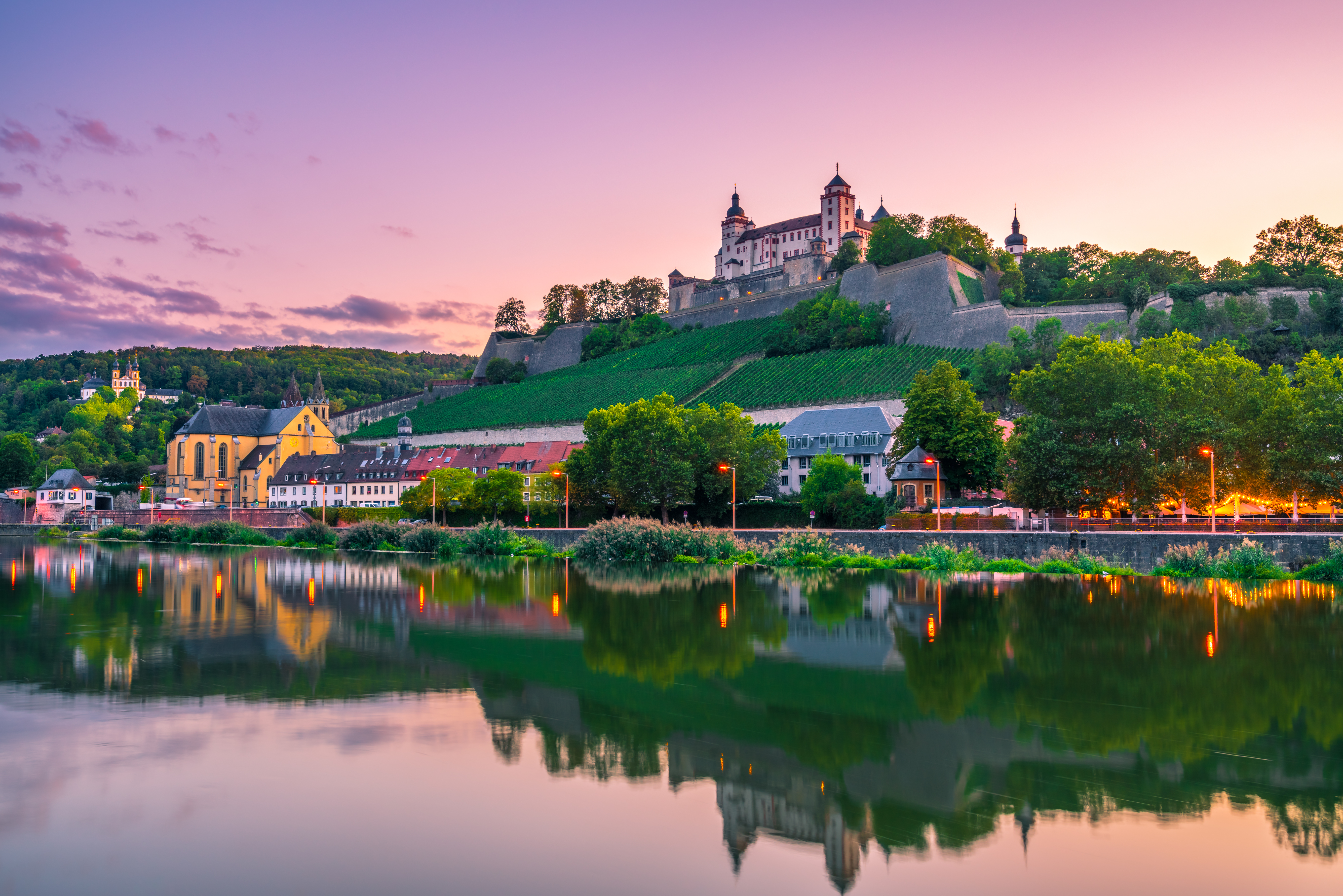 Historisk Marienberg Fæstning over Würzburgs skyline spejlet i Main-floden ved solnedgang