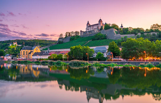 Historisk Marienberg Fæstning over Würzburgs skyline spejlet i Main-floden ved solnedgang