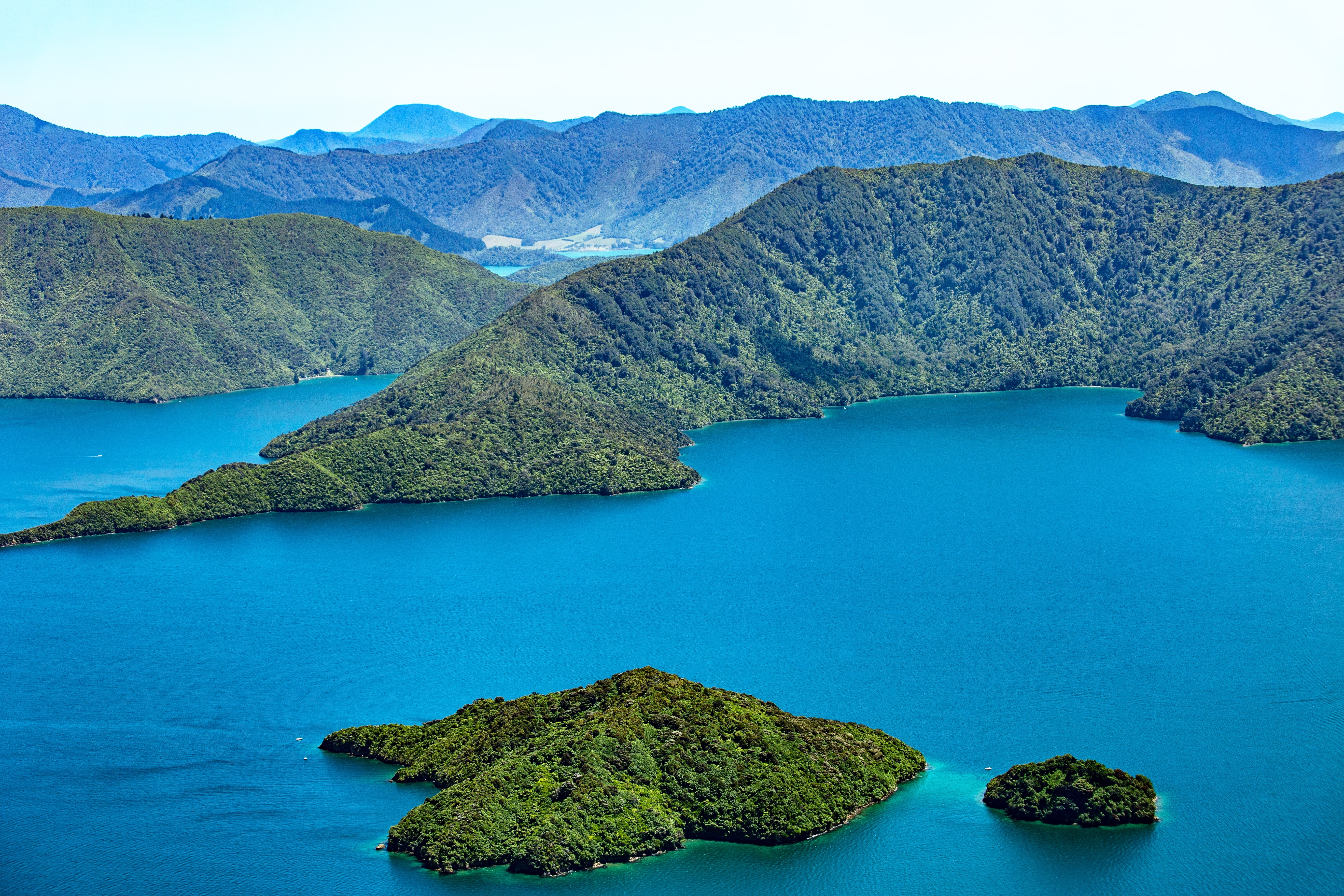 Malerisk udsigt fra luften over Marlborough Sounds med grønne øer, turkisblåt vand og bjergrige omgivelser på New Zealands Sydø
